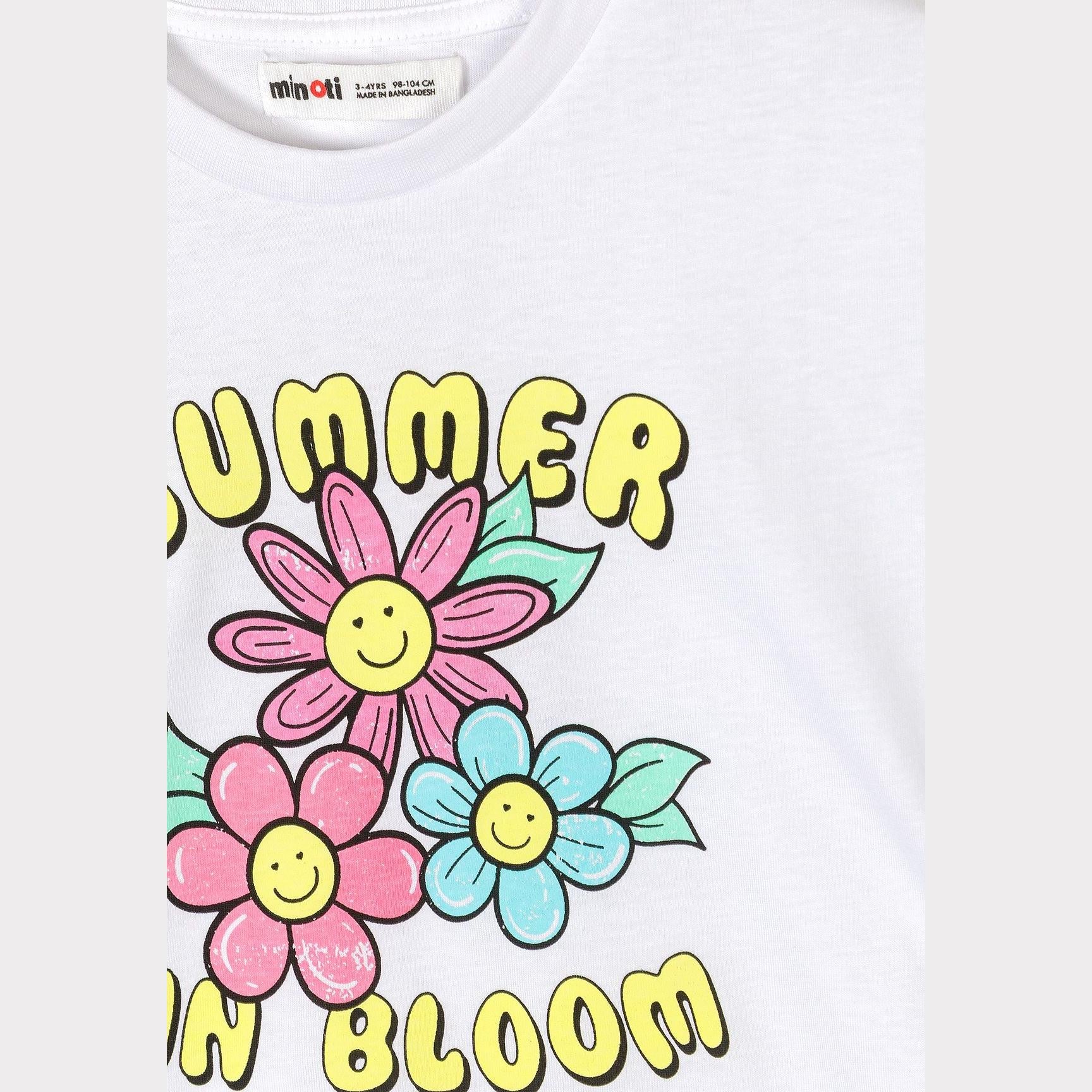 Close-up detail of white t-shirt showing Summer in Bloom print with smiling daisy flowers in pink and blue with yellow centers and green leaves
