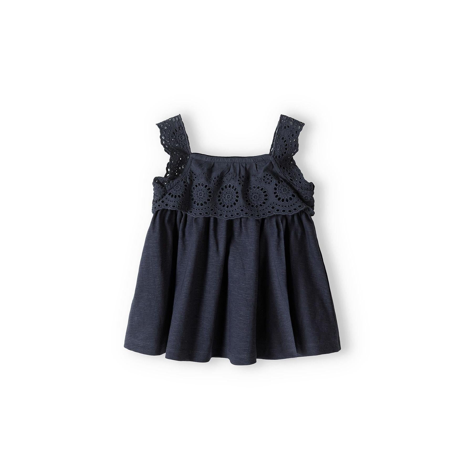 Grey broderie anglaise sleeveless top with ruffle neckline detail and shoulder straps, laid flat on white background