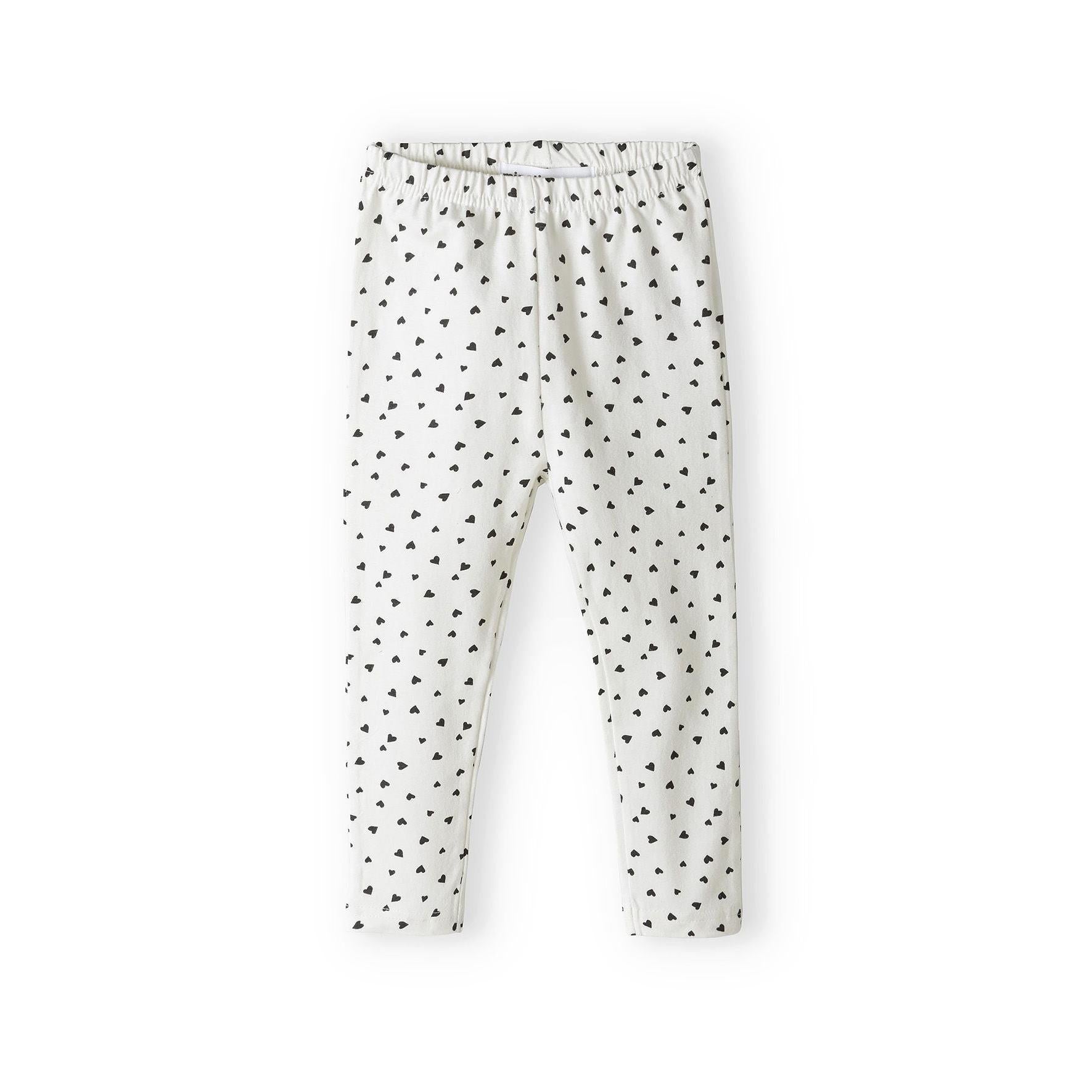Cream coloured leggings with black heart print pattern all over, laid flat on white background