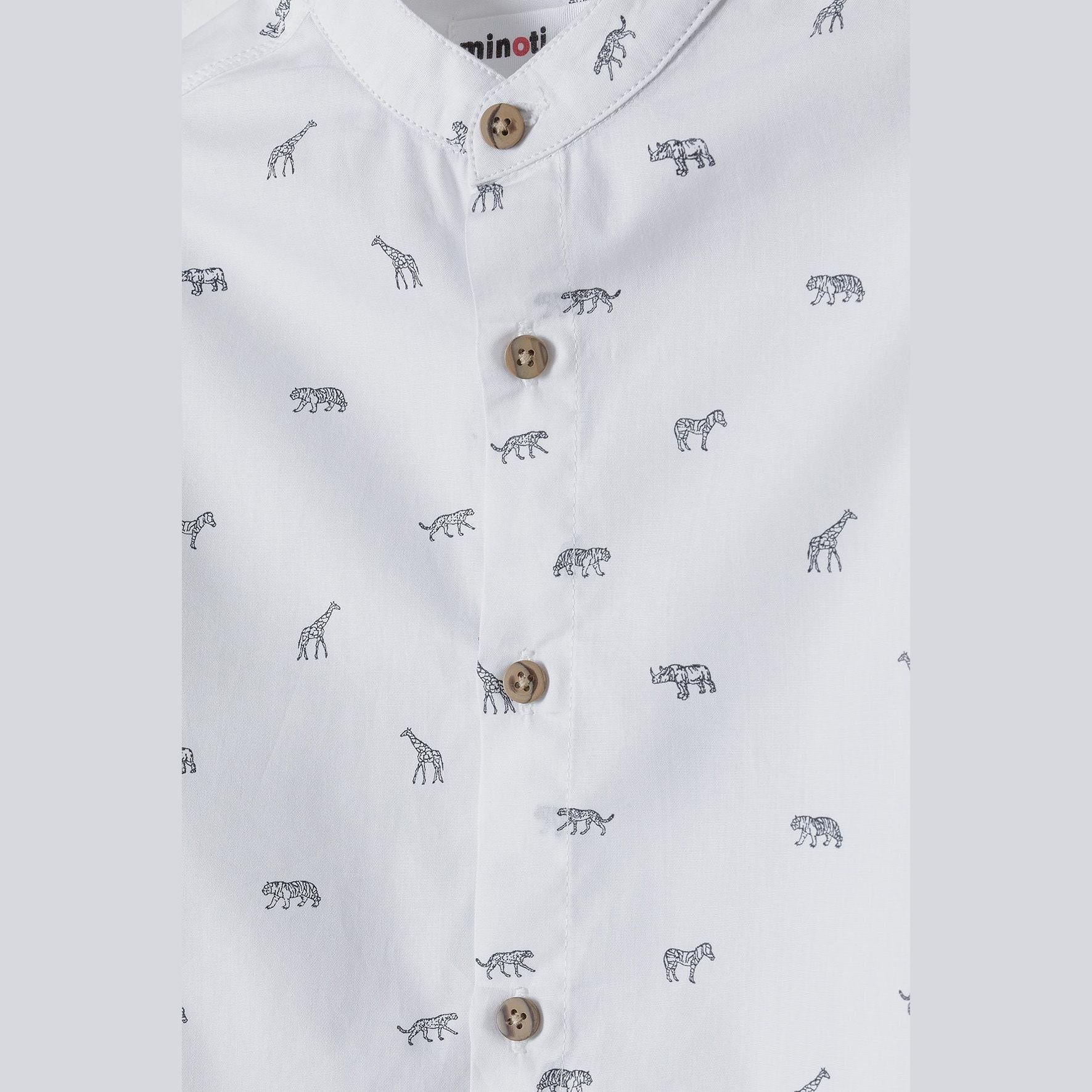 Close-up detail of white shirt showing safari animals print, wooden buttons and Minoti brand label on collar