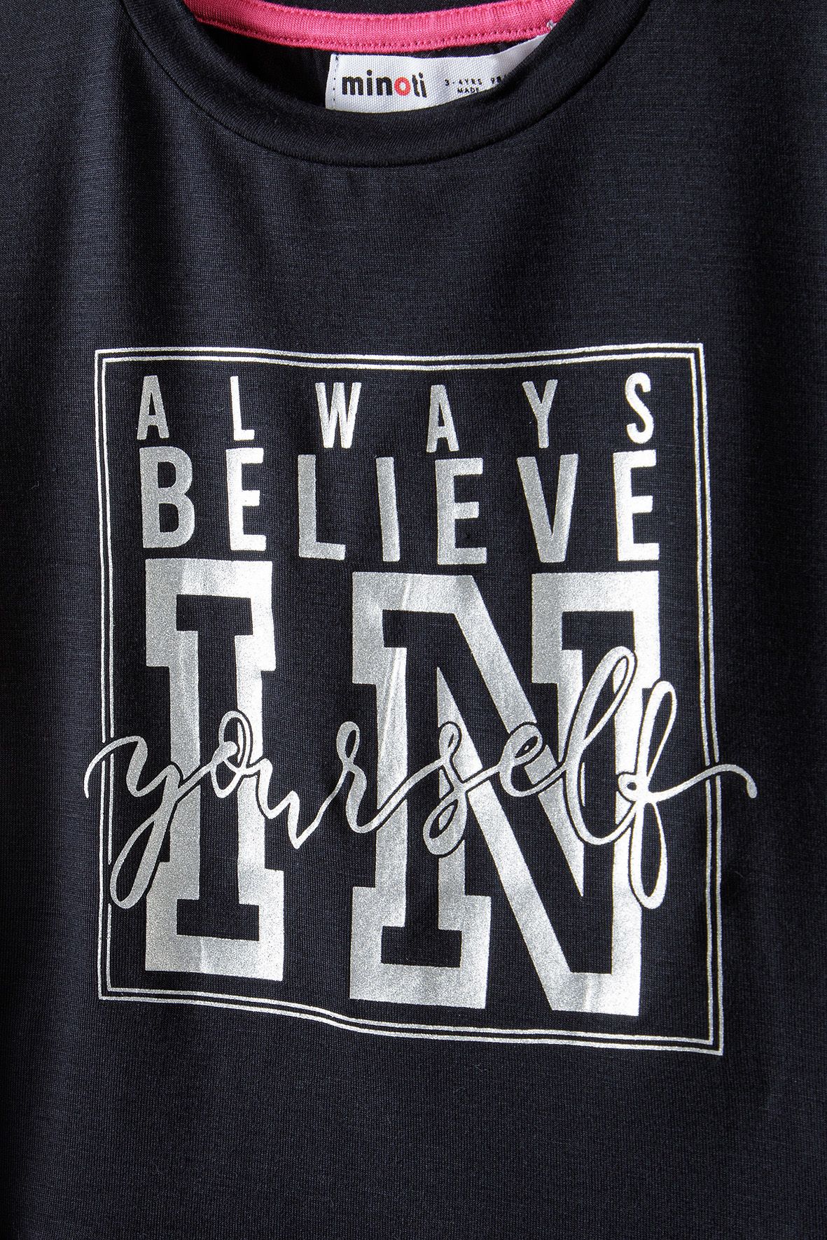 Close-up of silver-tone Always Believe In Yourself slogan print on black T-shirt.