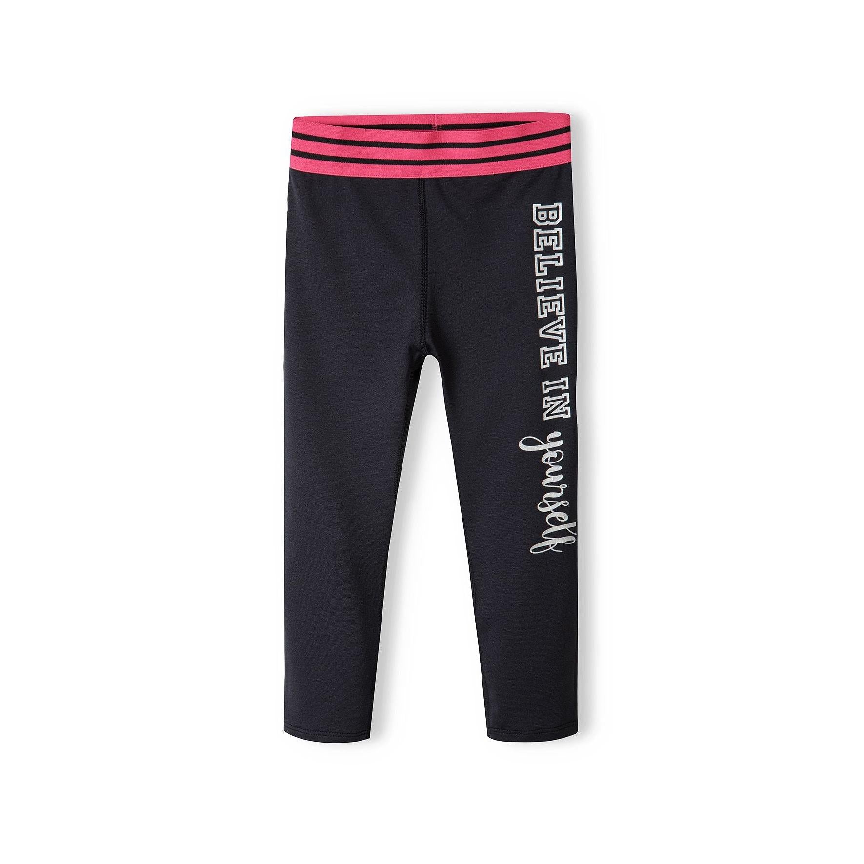 Flat lay view of black sport leggings showing pink and black striped elasticated waistband detail against white background