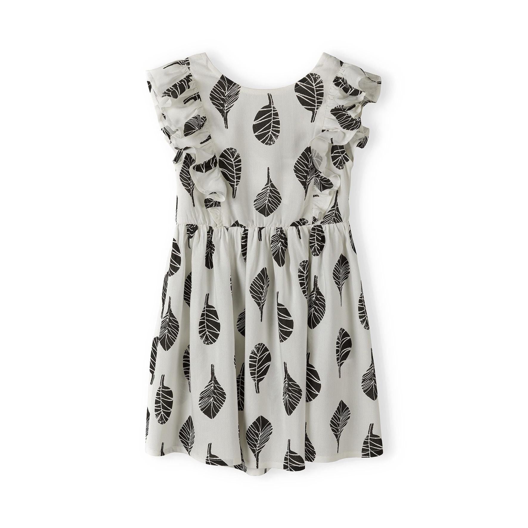 White summer dress with black leaf print laid flat showing full dress design and frill sleeve details