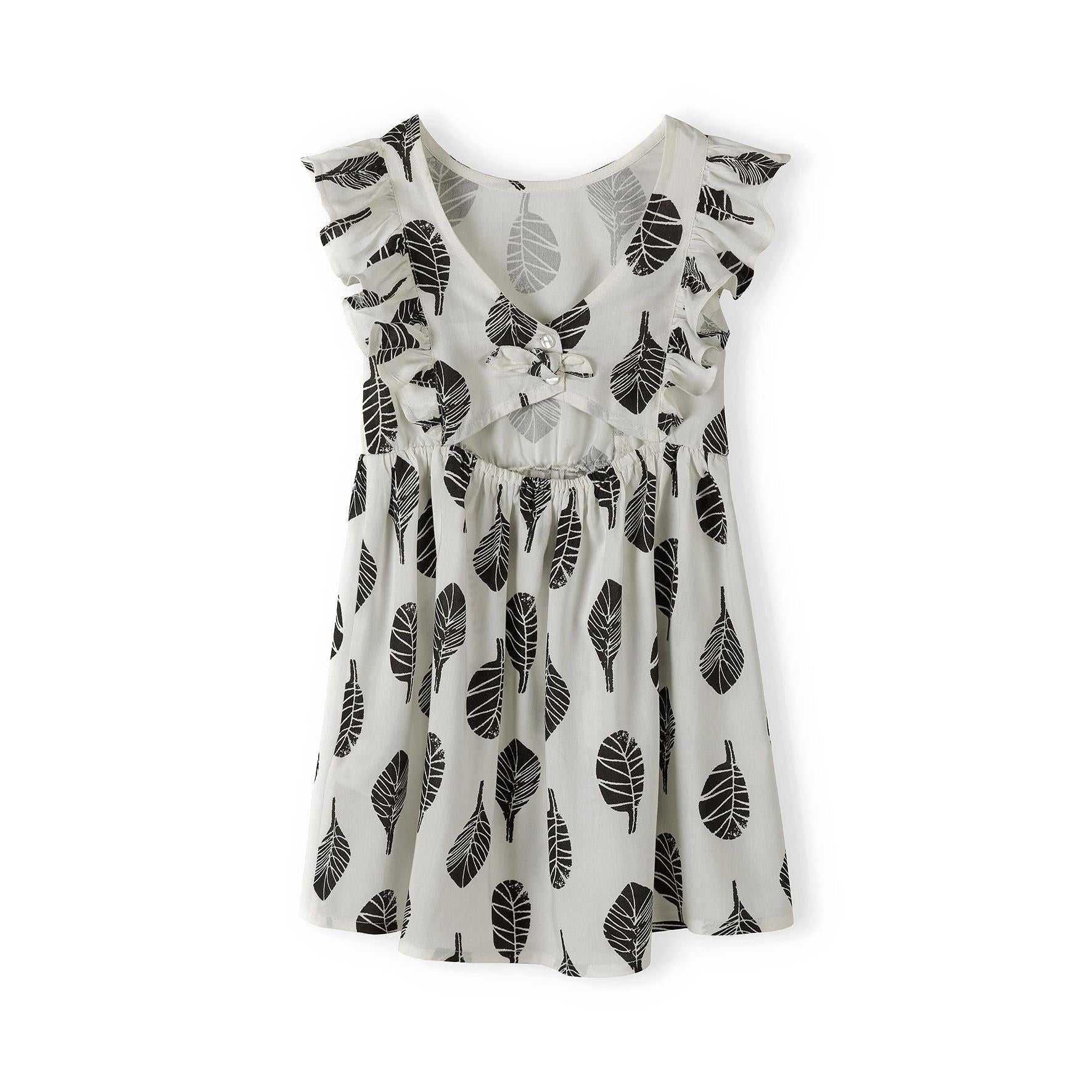 White summer dress with black leaf print laid flat showing full dress design and frill sleeve details