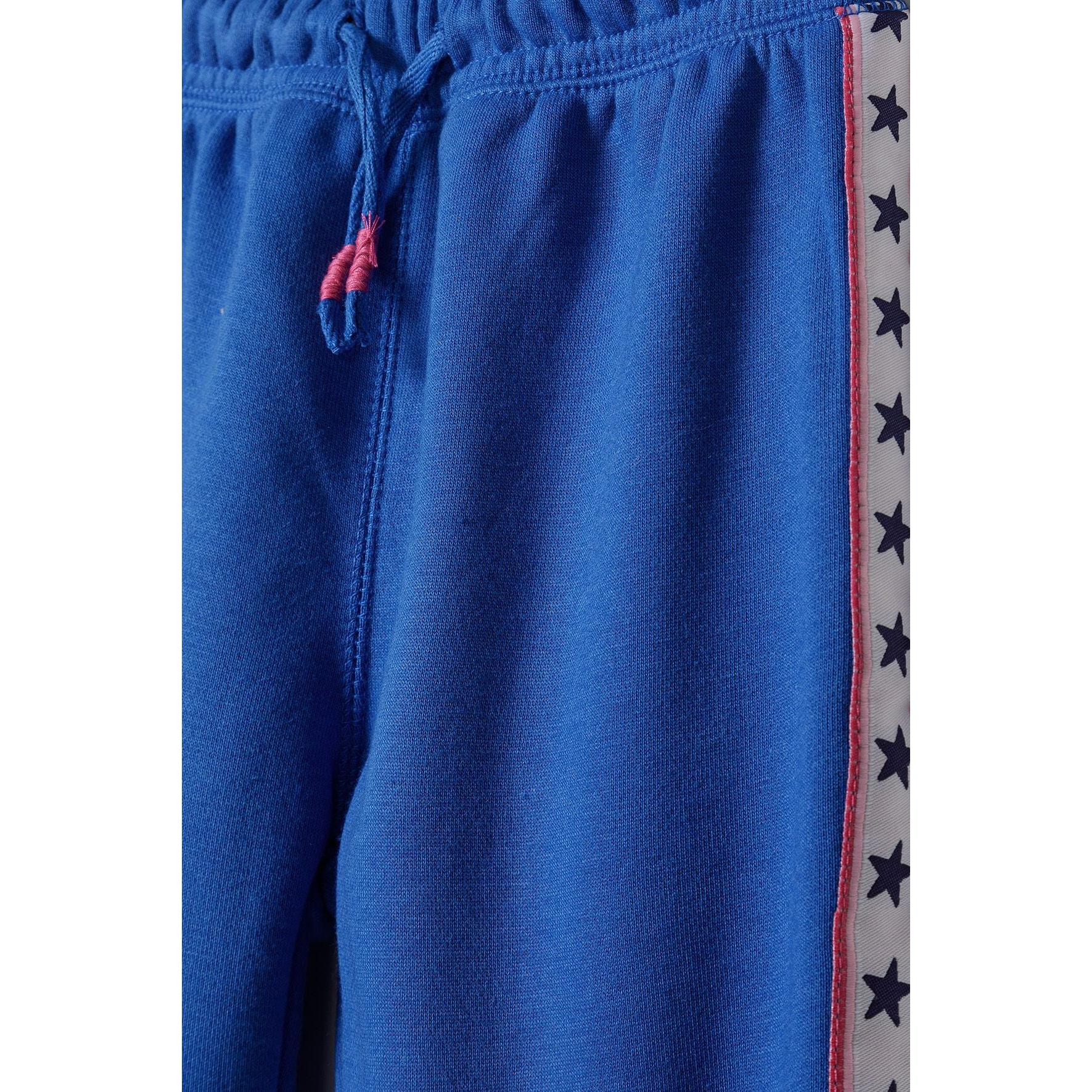 Close-up detail of blue fleece joggers showing drawstring waist and white side tape with navy star pattern