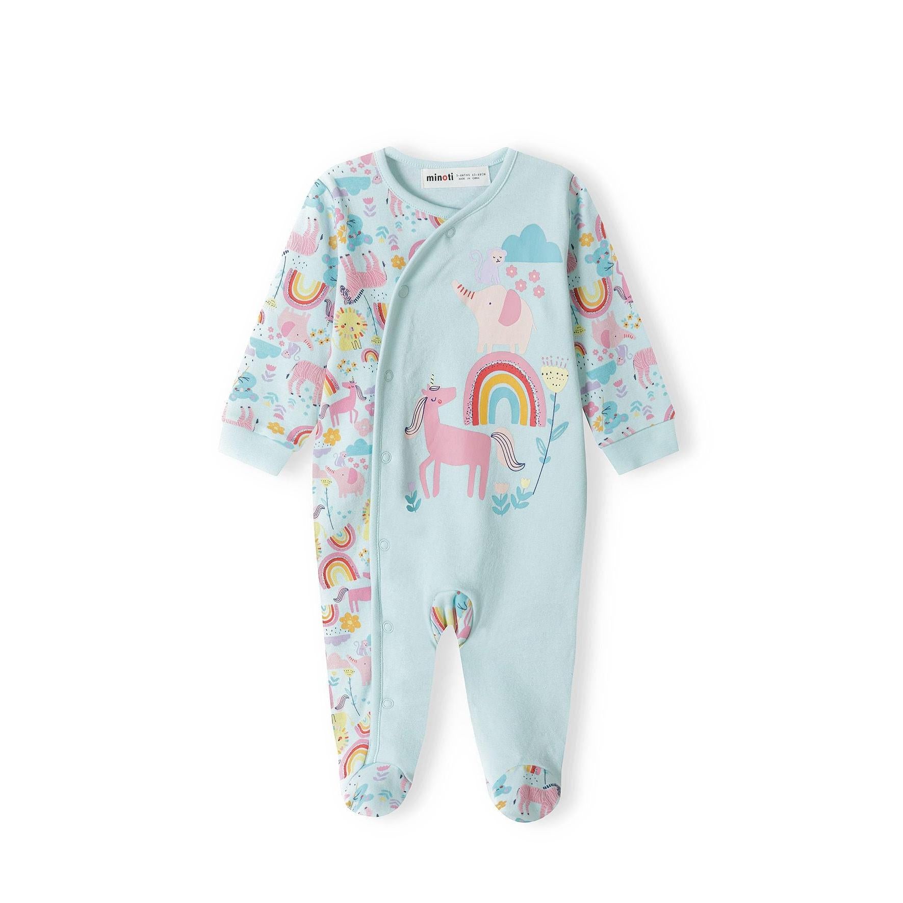 Back view of unicorn rainbow print baby sleepsuit displaying colorful pattern with unicorns, rainbows, stars and clouds on light blue background with enclosed feet
