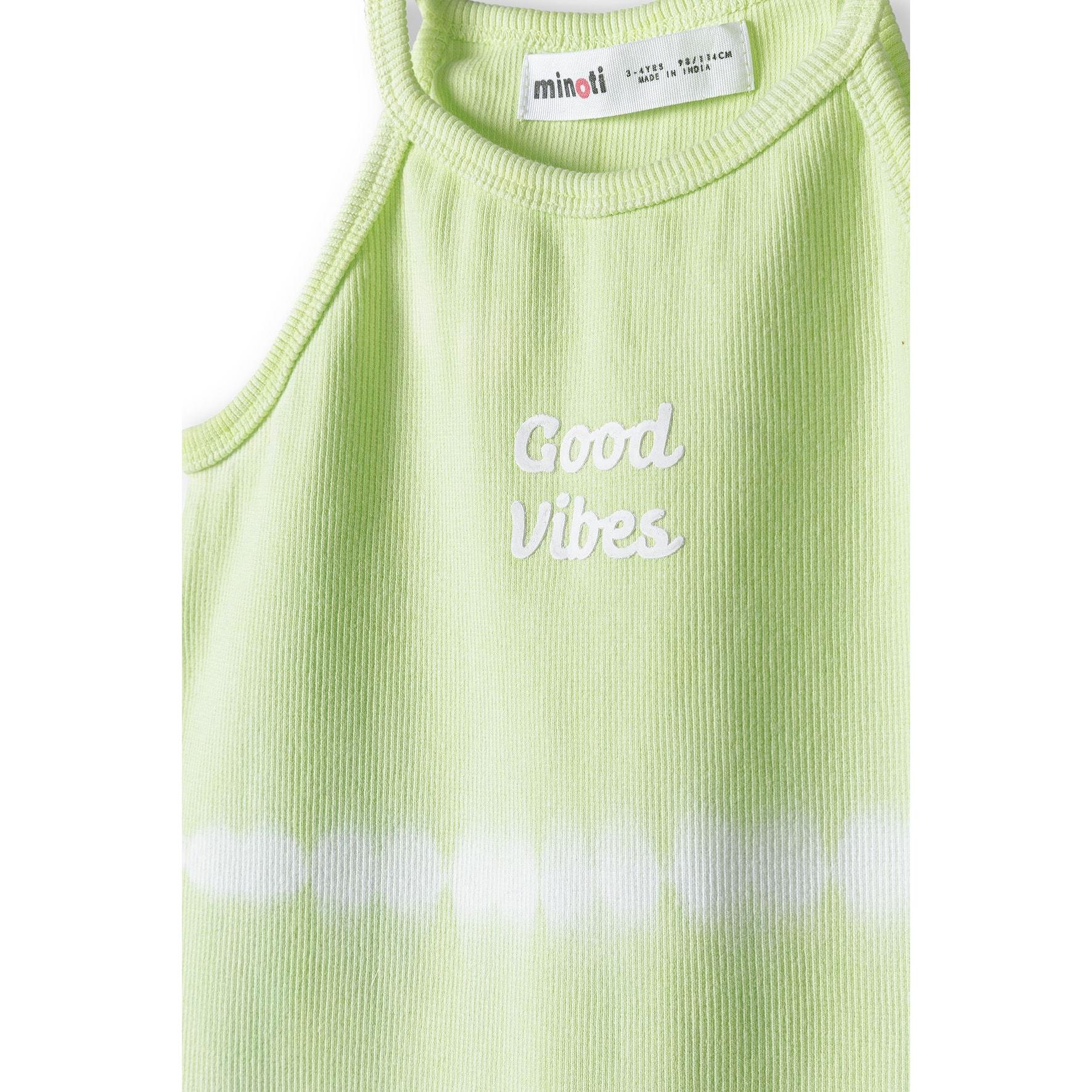 Close-up detail of lime green ribbed vest showing Good Vibes white embroidered text and Minoti label at neckline