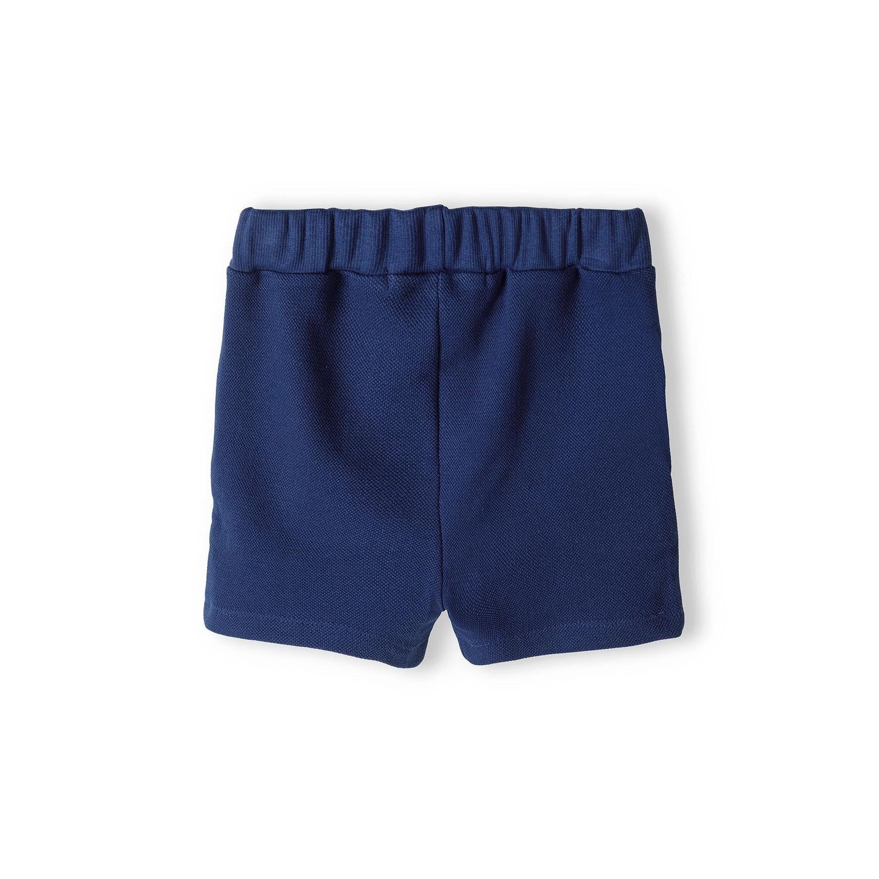 Navy blue shorts laid flat showing elasticated waistband with ruffle detail and comfortable fit design on white background