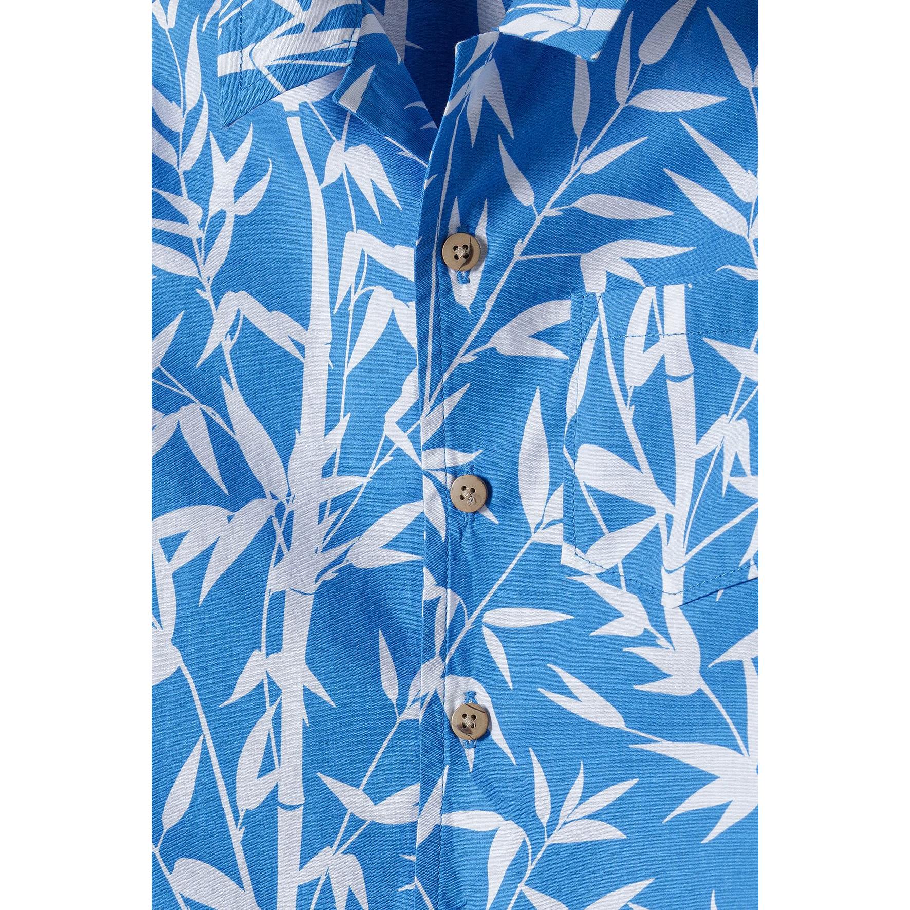 Close-up detail of the bamboo leaf print pattern and button closure on blue poplin fabric showing texture and design clarity
