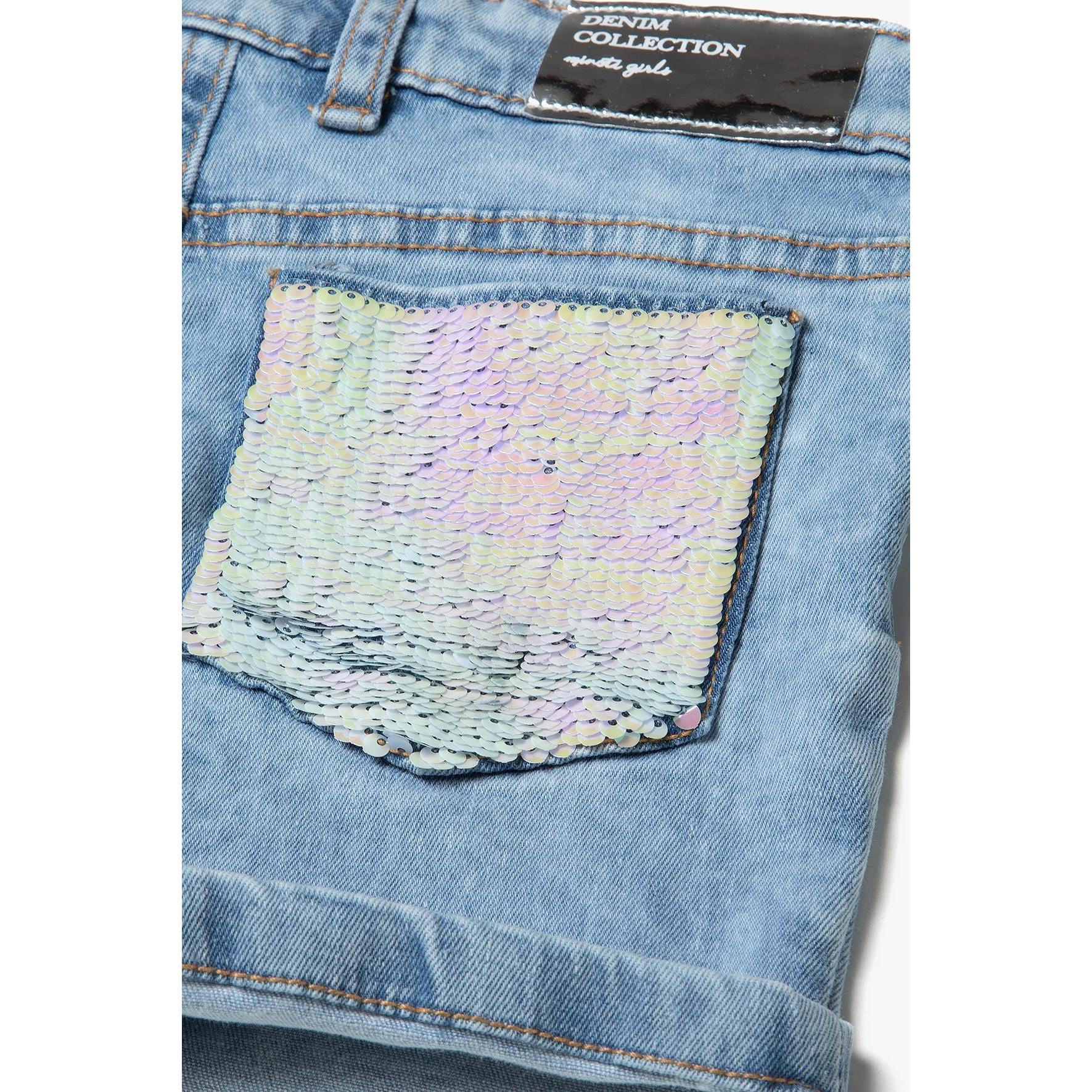 Close-up of back pocket with white sequin embellishment on light blue denim, showing turn-up hem detail and contrast stitching