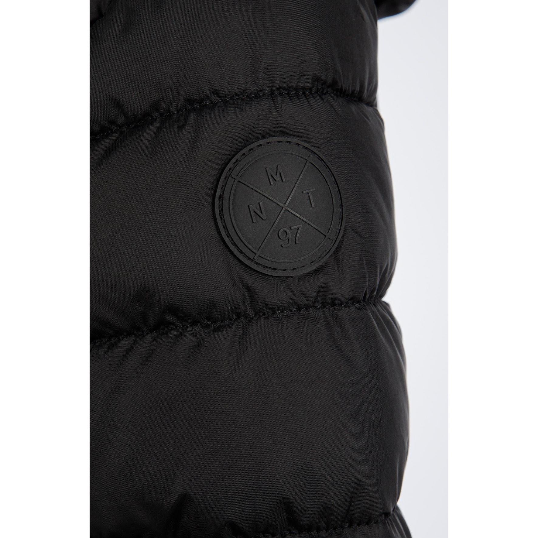 Detail view of black quilted jacket sleeve showing padded construction and embossed circular Minoti logo patch
