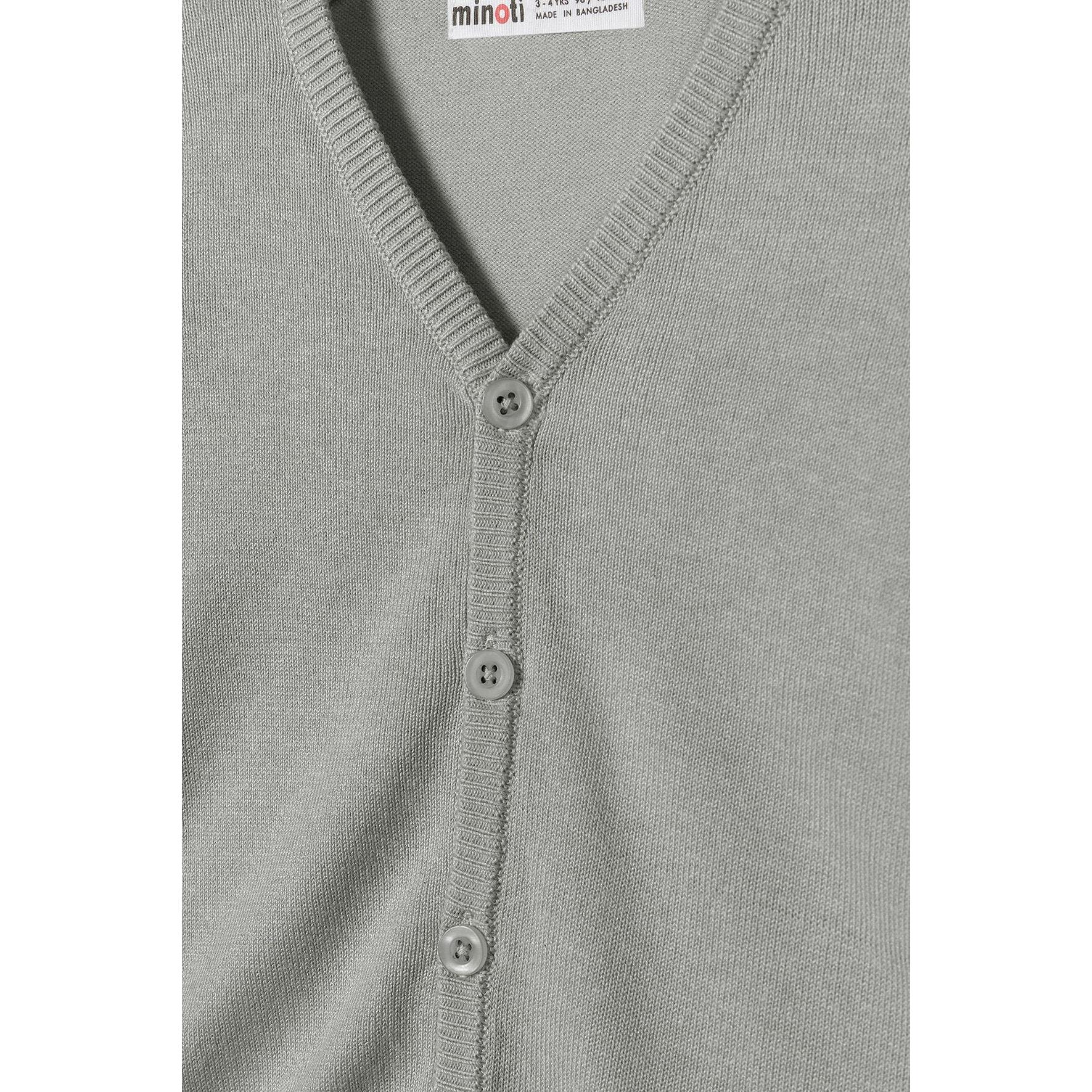 Close-up detail of grey knitted cardigan showing Minoti label, V-neckline construction and button placement with ribbed neckband