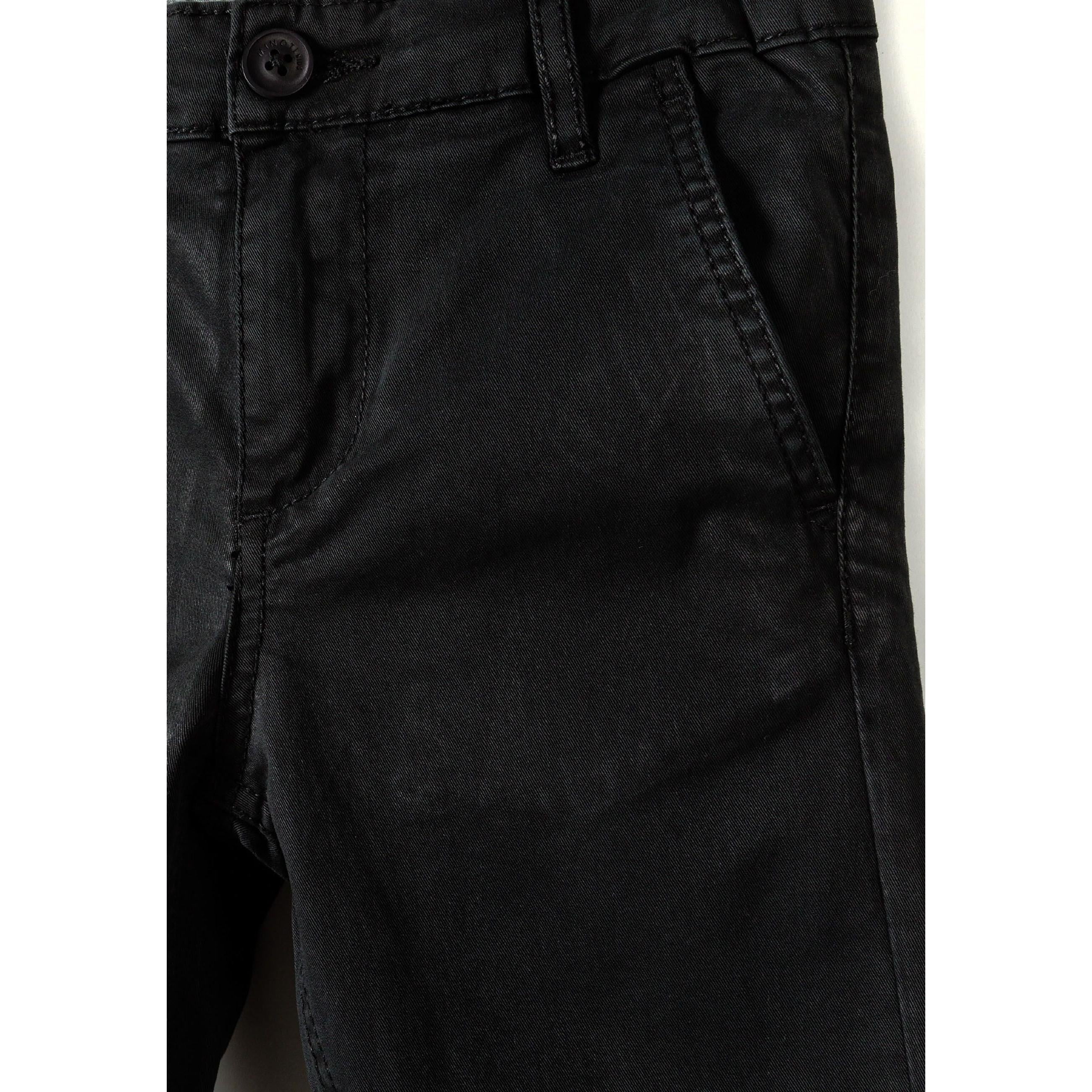 Close-up detail of black chino trouser waistband showing button closure, belt loops and front pocket with quality stitching
