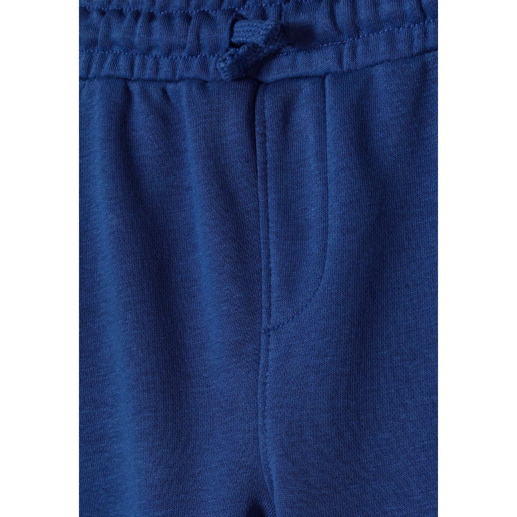 Close-up detail of cobalt blue joggers waistband showing elasticated drawstring waist with matching blue cord and soft fleece texture