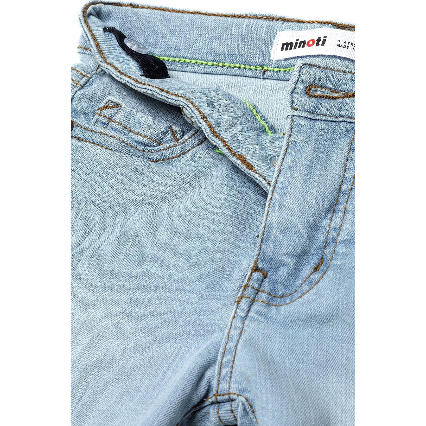 Close-up detail view of light blue denim shorts showing Minoti waistband label and front pocket construction on white background
