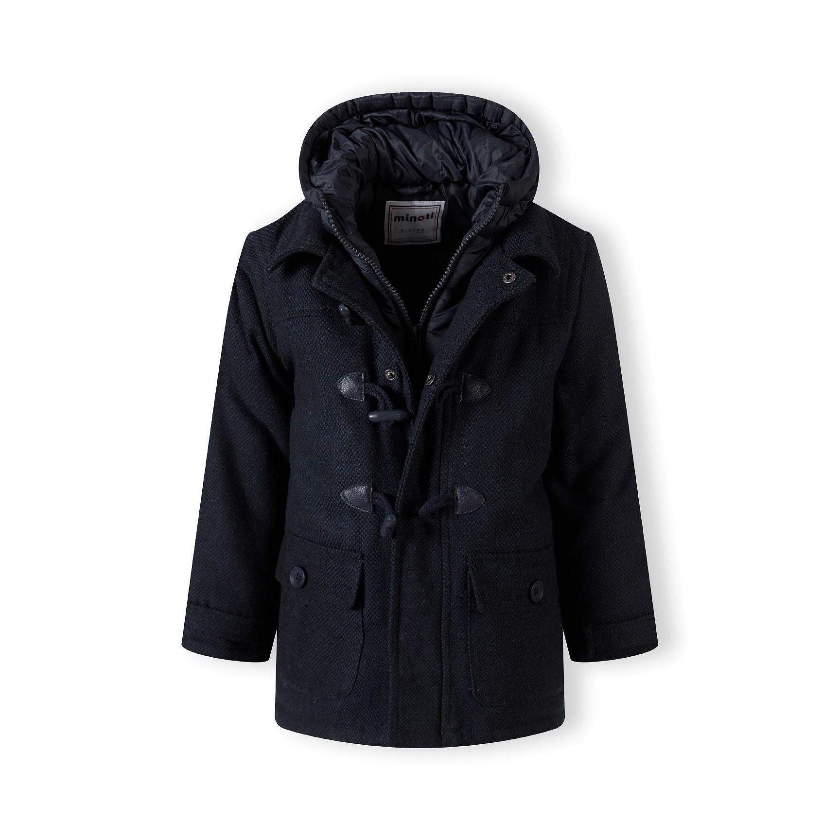 Close-up detail of navy duffle coat showing textured fabric, wooden toggle fastening and patch pocket with button