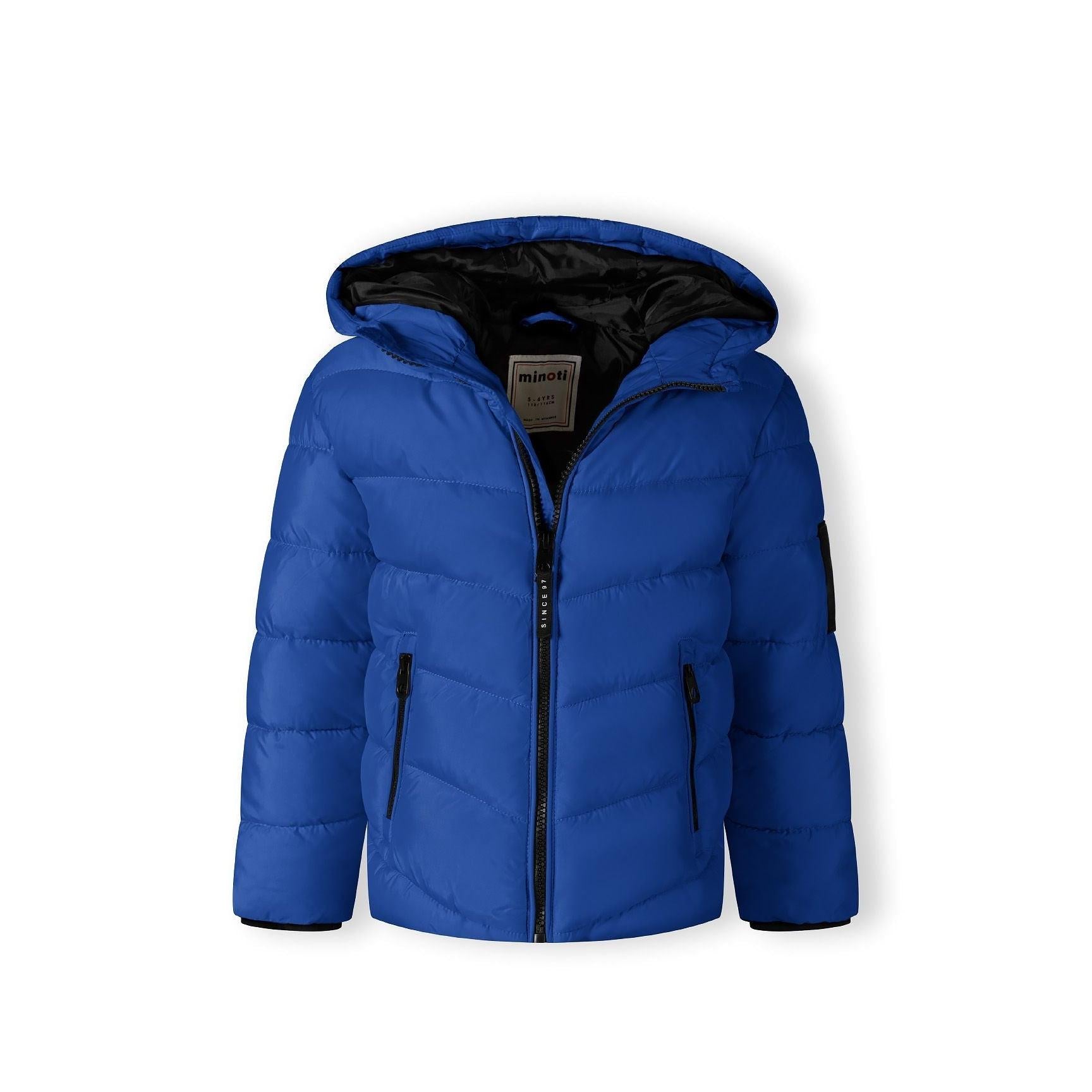 Close-up detail of black fabric label on cobalt blue jacket showing MNT brand text and authenticity information