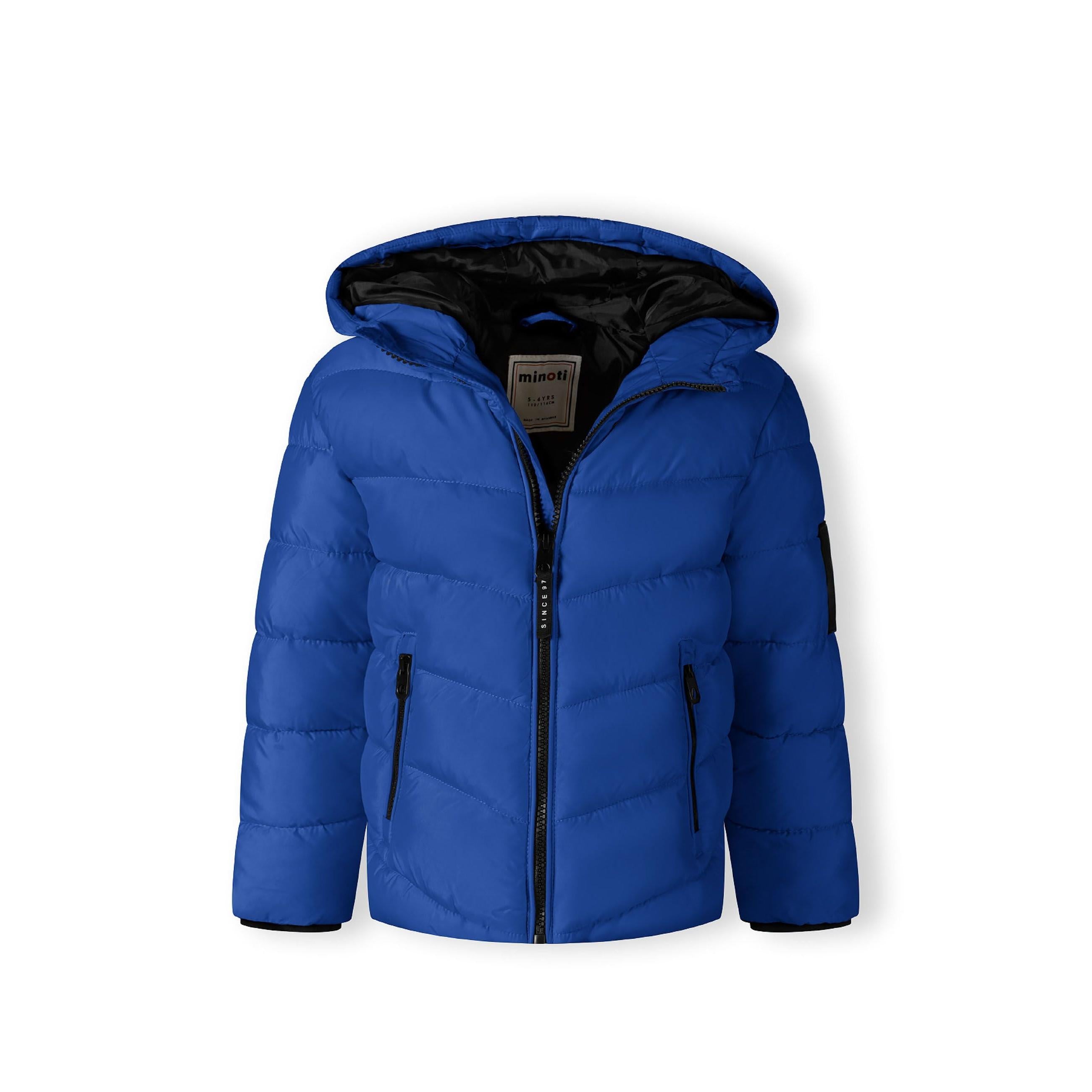 Close-up detail of black fabric label on cobalt blue jacket showing MNT brand text and authenticity information