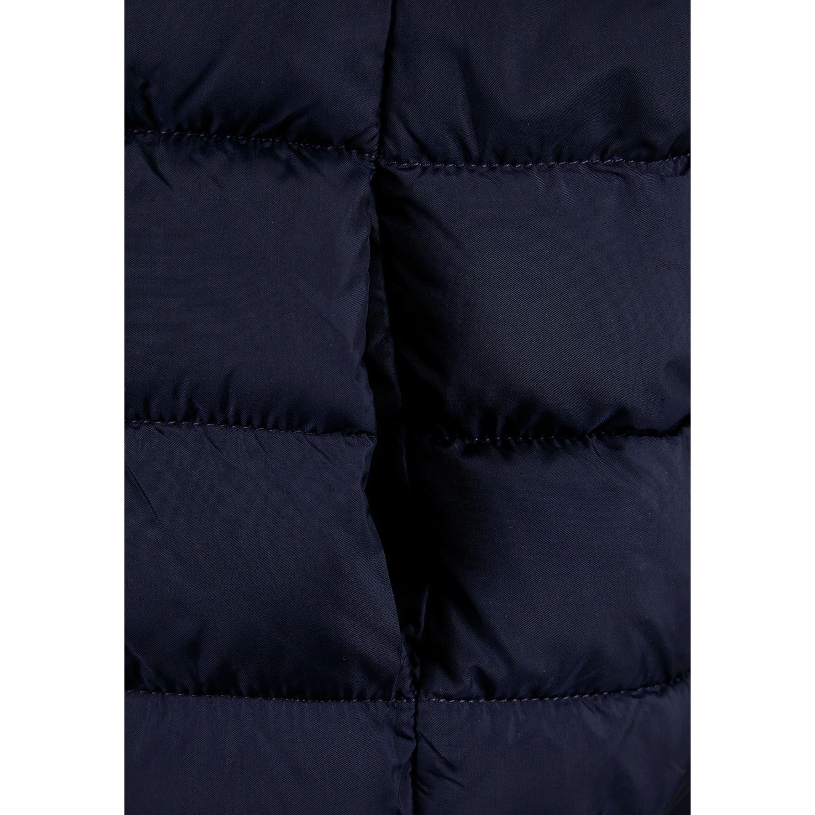 Close-up detail of navy padded gilet showing full zip closure, quilted panels and fabric texture on dark background
