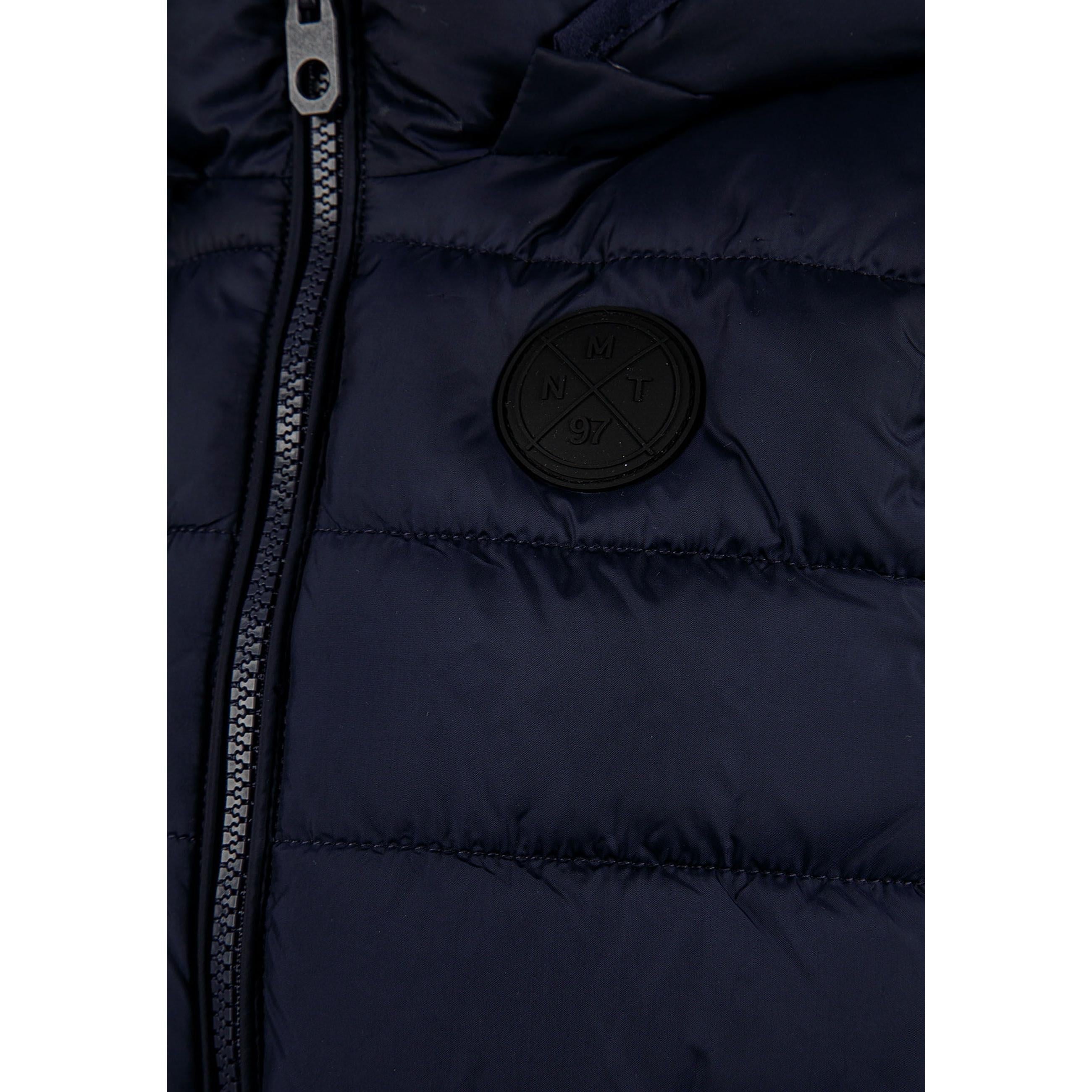 Close-up detail of navy padded gilet showing full zip closure, quilted panels and fabric texture on dark background