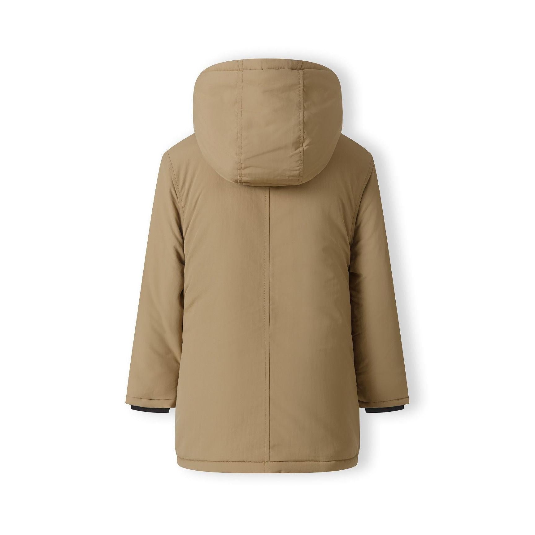 Close-up detail of black circular logo patch on beige parka jacket sleeve showing crossed design elements