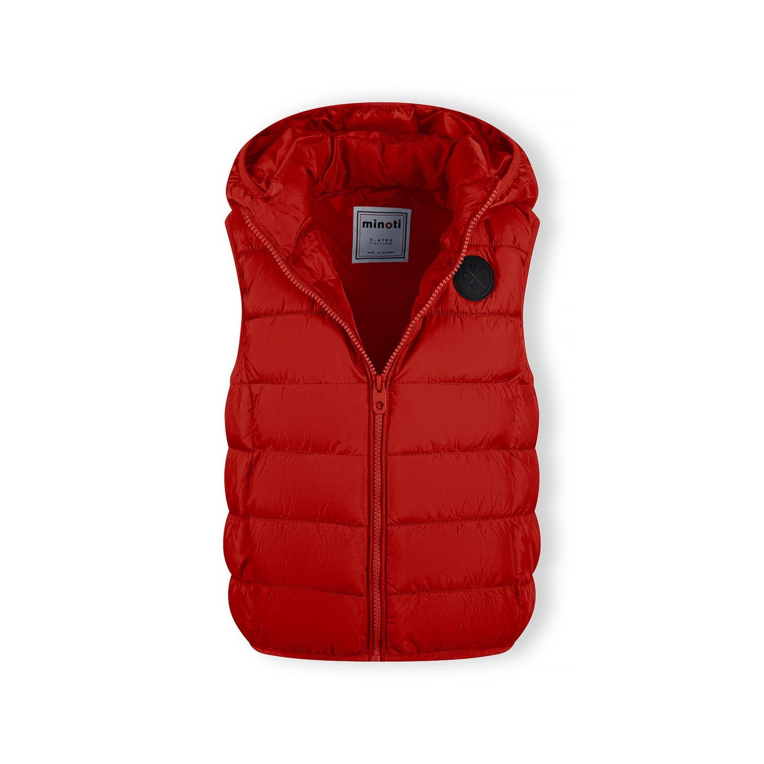 Close-up detail of red padded gilet showing quilted texture, zip fastener and gathered hood construction