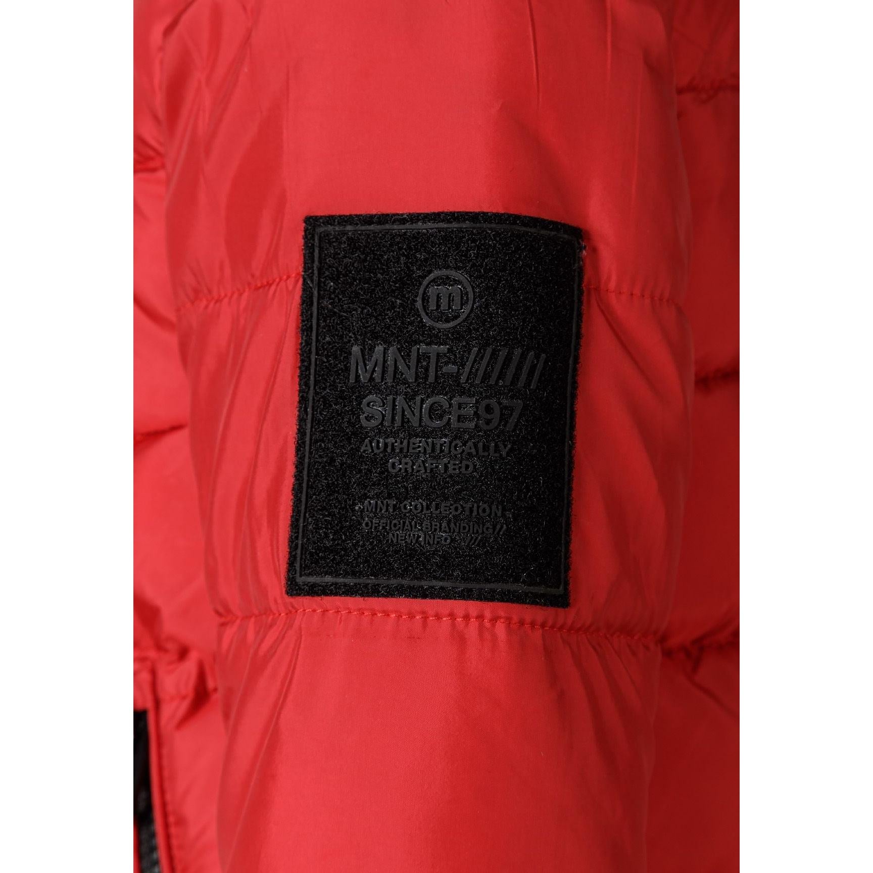 Close-up detail of black Minoti brand patch on red quilted jacket fabric showing logo and text