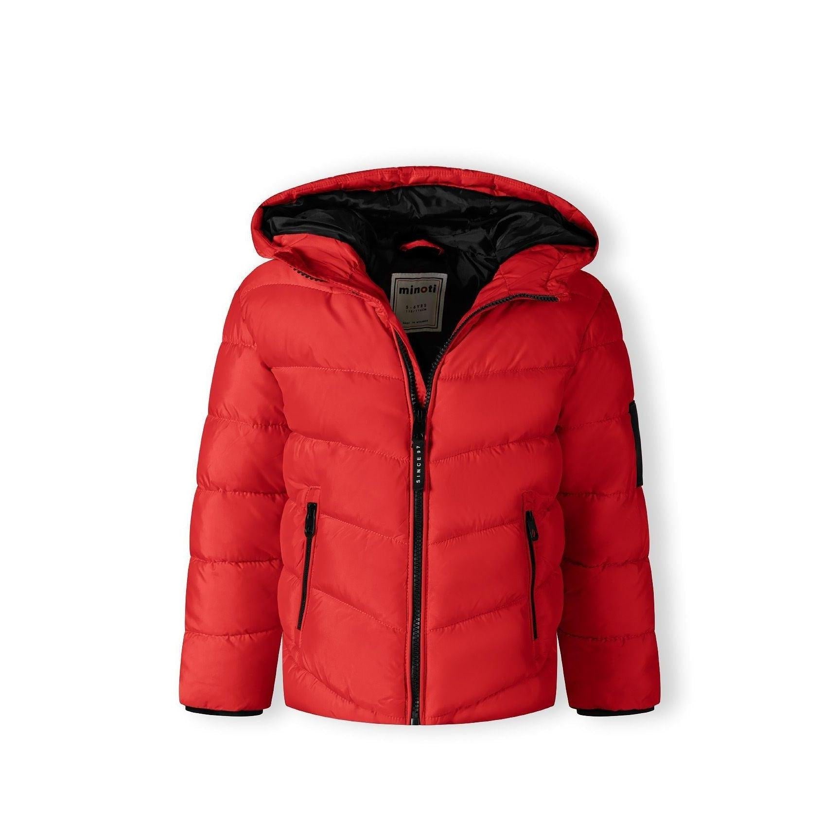 Close-up detail of black Minoti brand patch on red quilted jacket fabric showing logo and text
