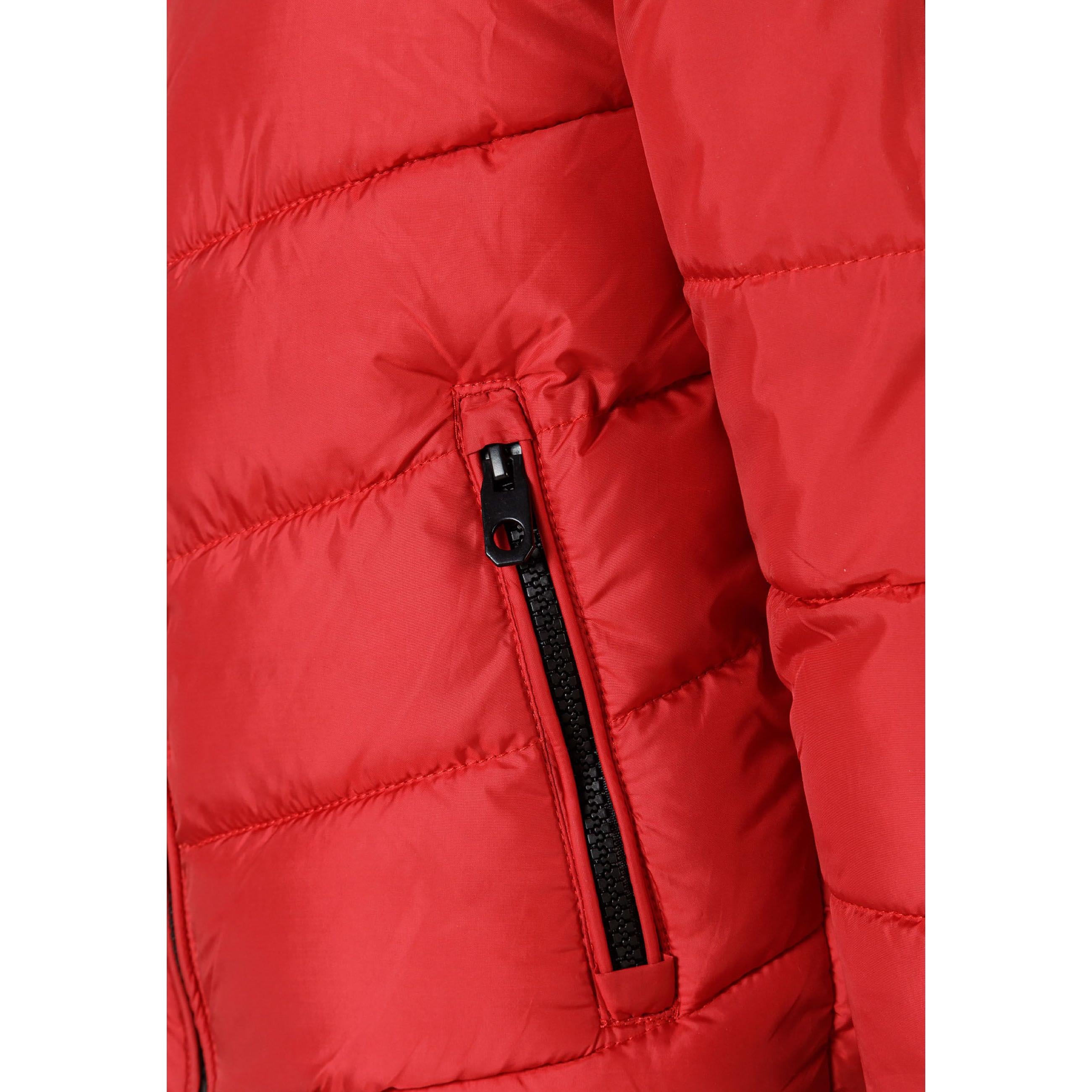 Close-up detail of black Minoti brand patch on red quilted jacket fabric showing logo and text