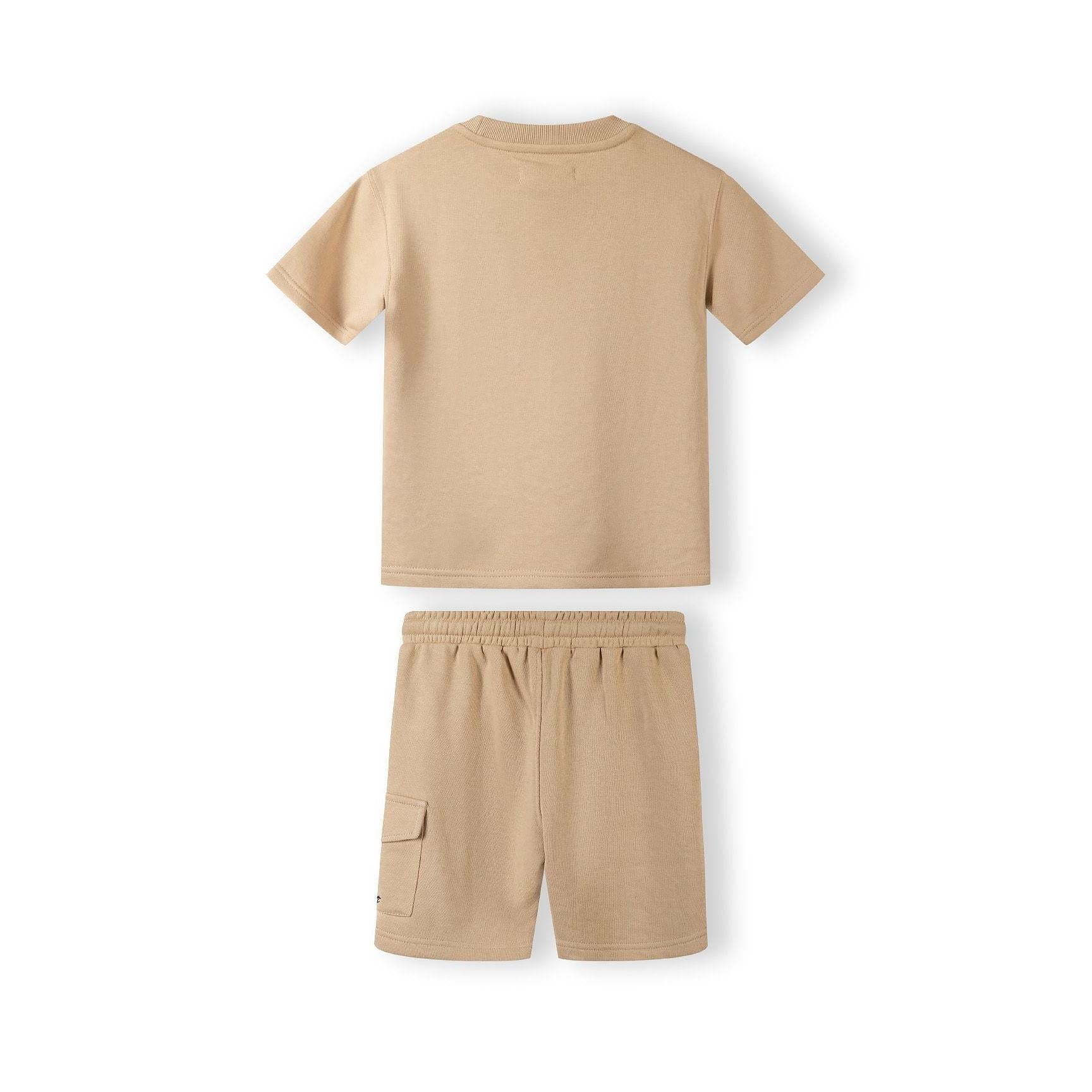 Close-up detail of beige cotton shorts showing elasticated waistband with black drawstring and Minoti label