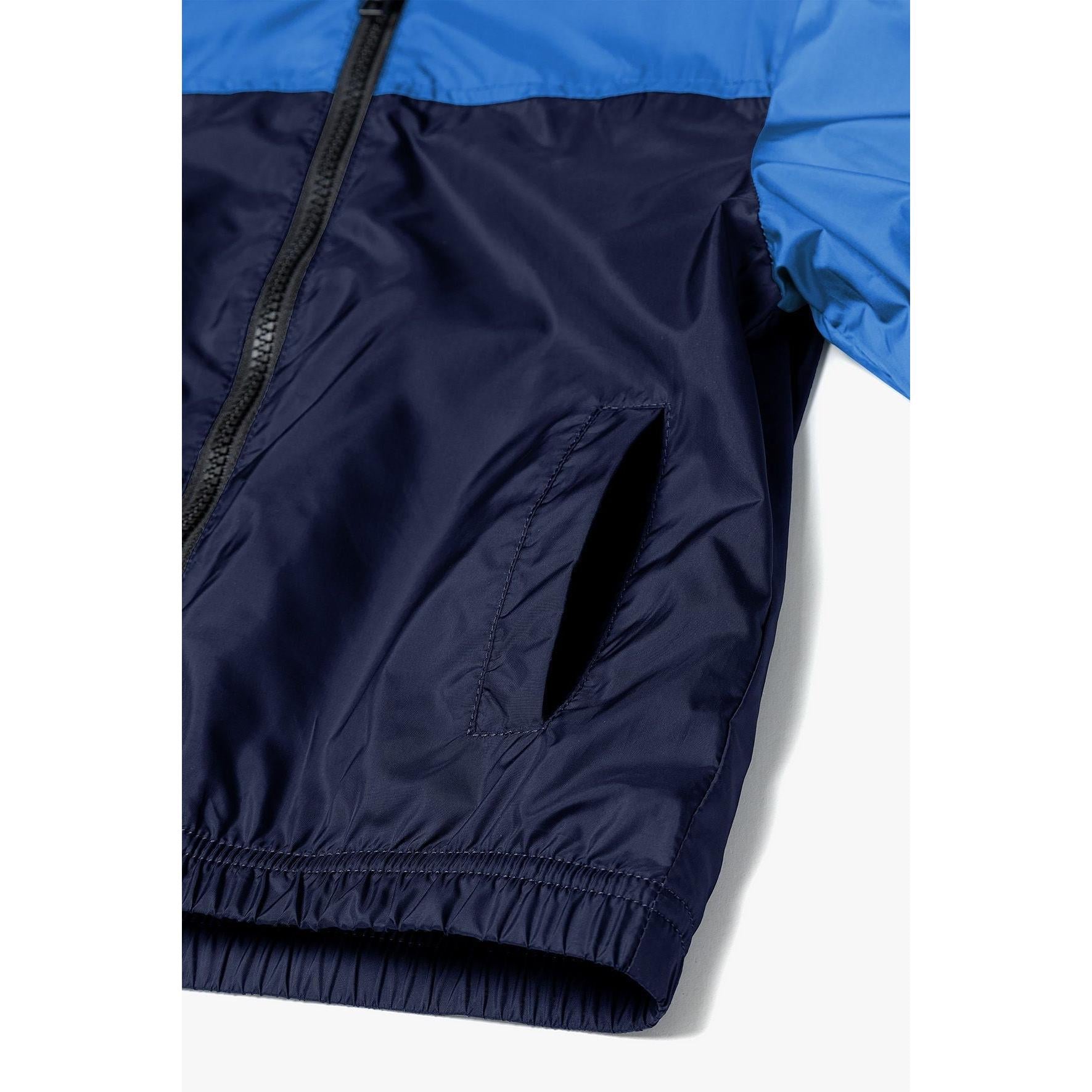 Close-up detail of windbreaker jacket showing front zip, hood lining, and Minoti brand label inside collar area