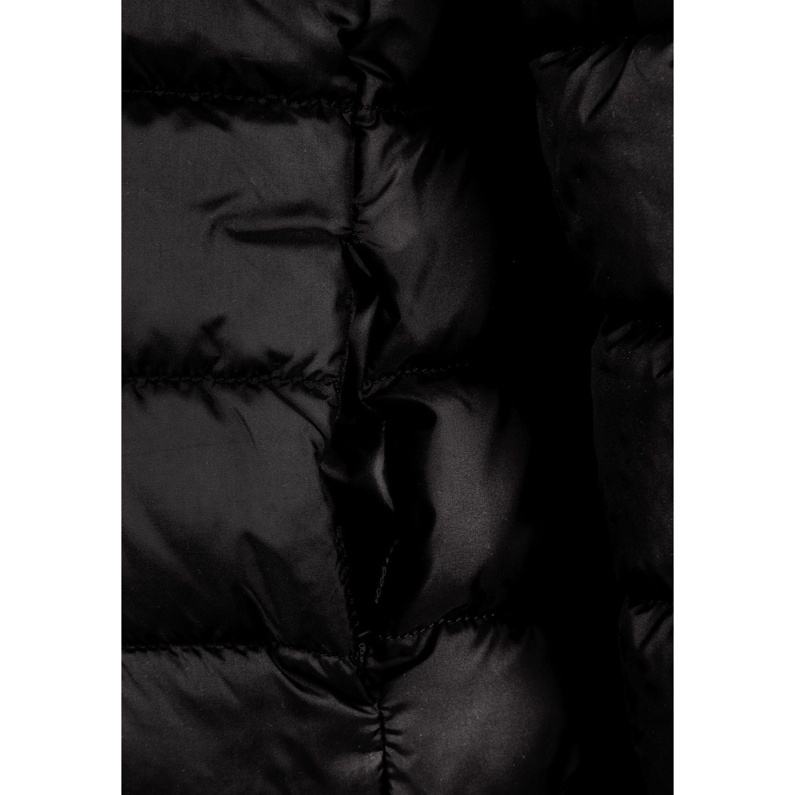 Close-up detail of black quilted fabric texture with zip fastening and hood construction