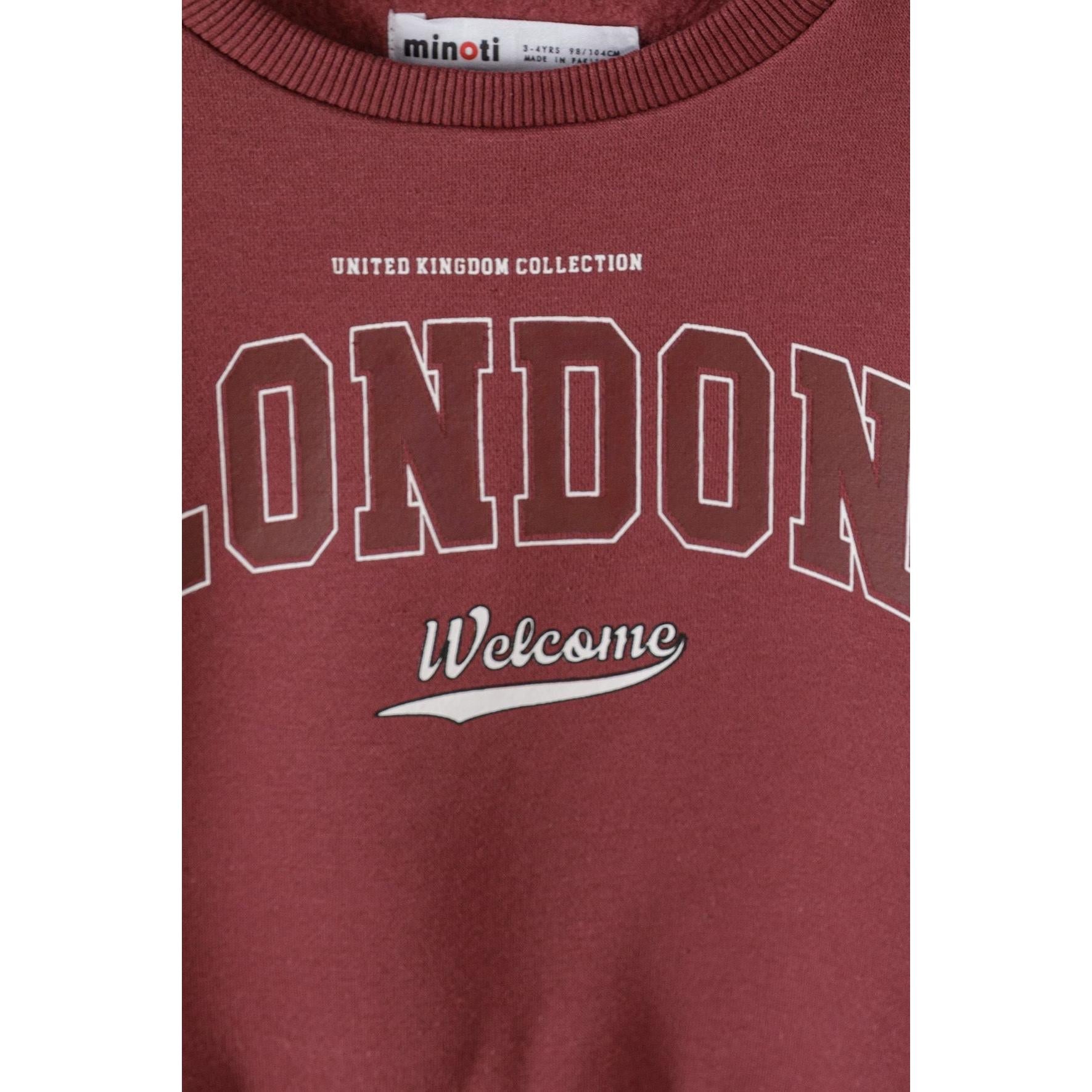 Close-up detail of burgundy sweatshirt showing Minoti label and London Welcome print with United Kingdom Collection text