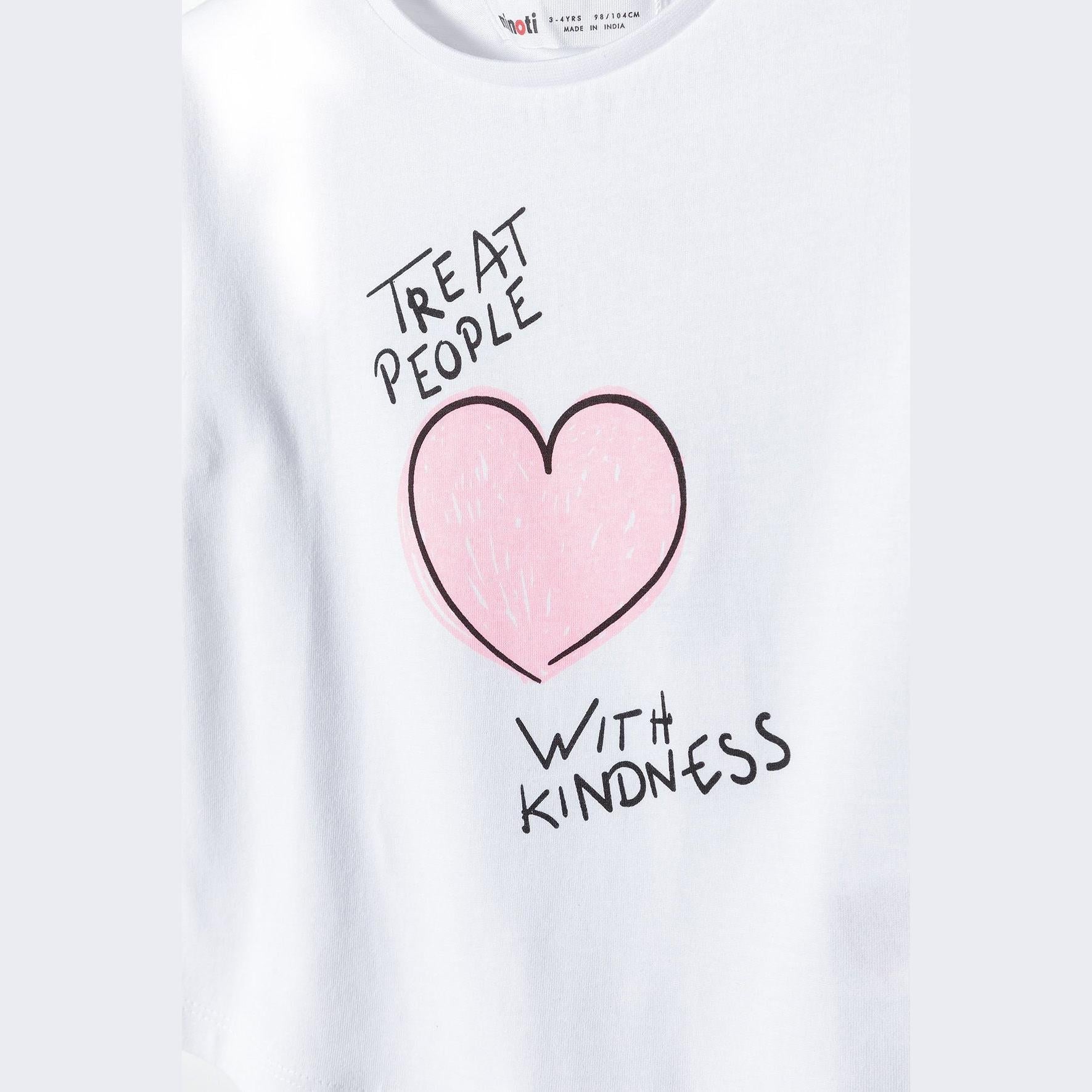 Close-up detail of 'Treat People With Kindness' text and pink heart graphic on white t-shirt fabric
