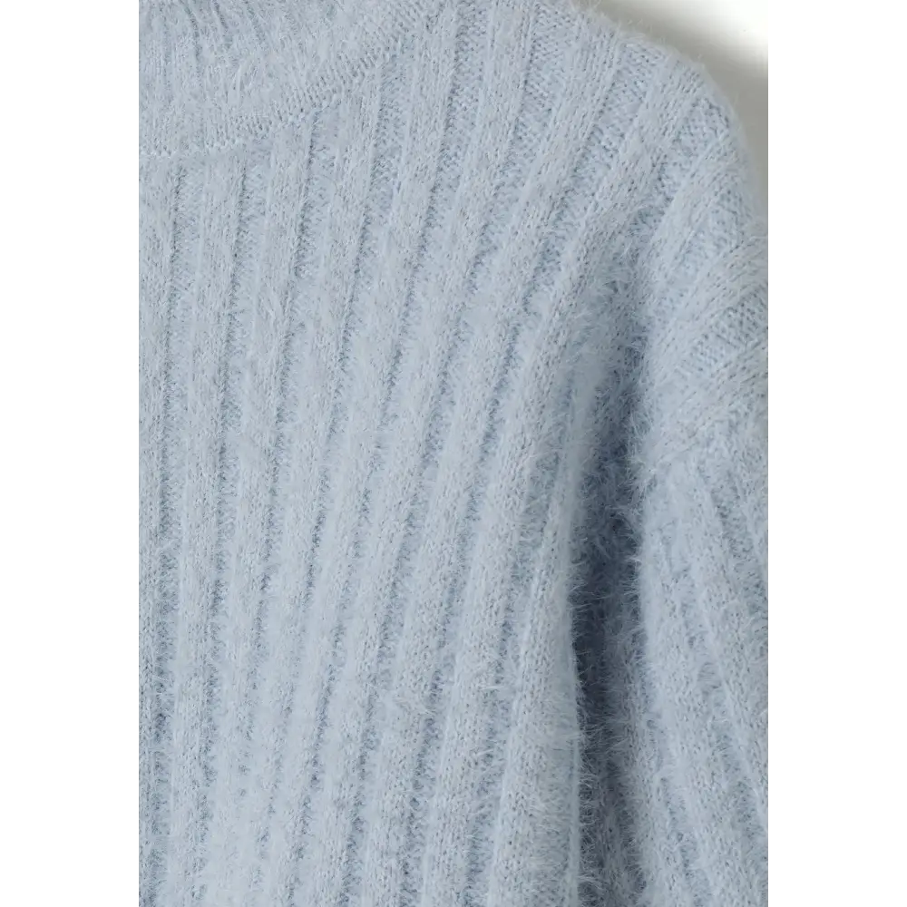 Close-up detail of blue fluffy knit fabric texture showing soft ribbed pattern and quality construction