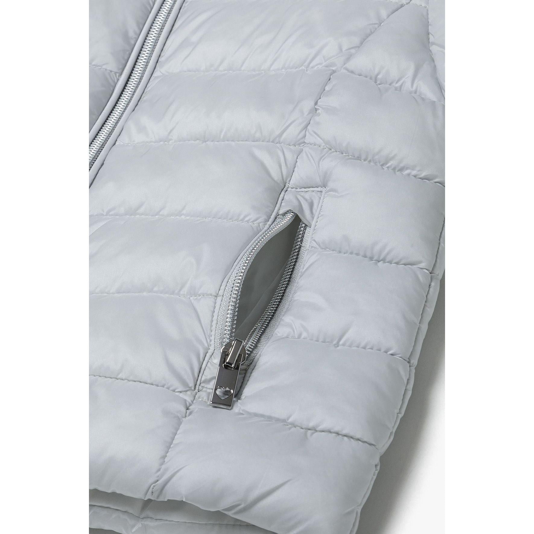 Close-up detail of silver-grey quilted jacket showing zip pocket with grey zipper pull and quilted texture
