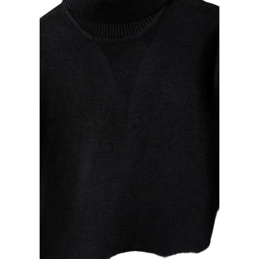 Close-up detail of black fine knit turtleneck jumper showing texture and fold-over collar construction