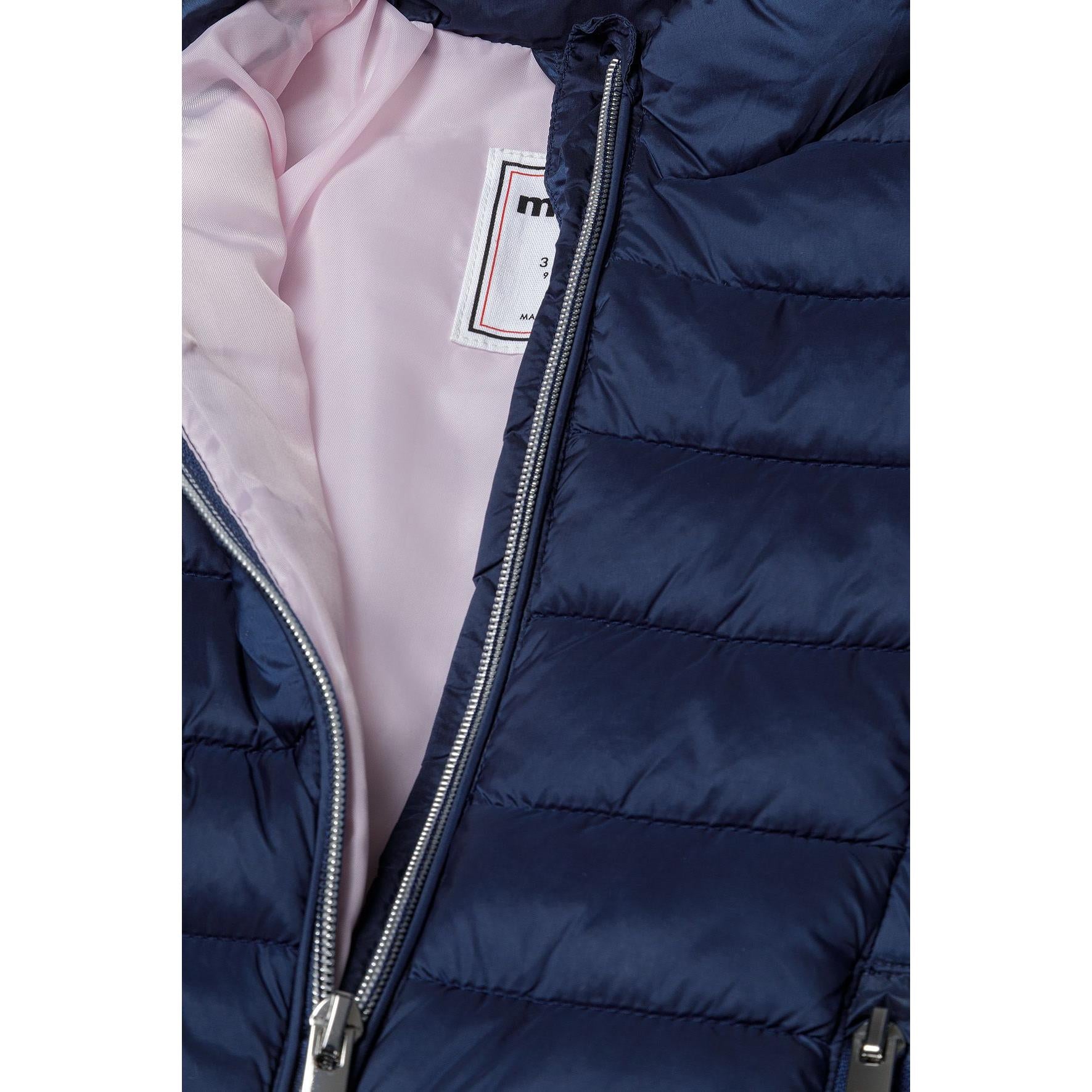 Close-up detail of navy quilted jacket showing zip pocket, quilted padding texture and metal zipper hardware