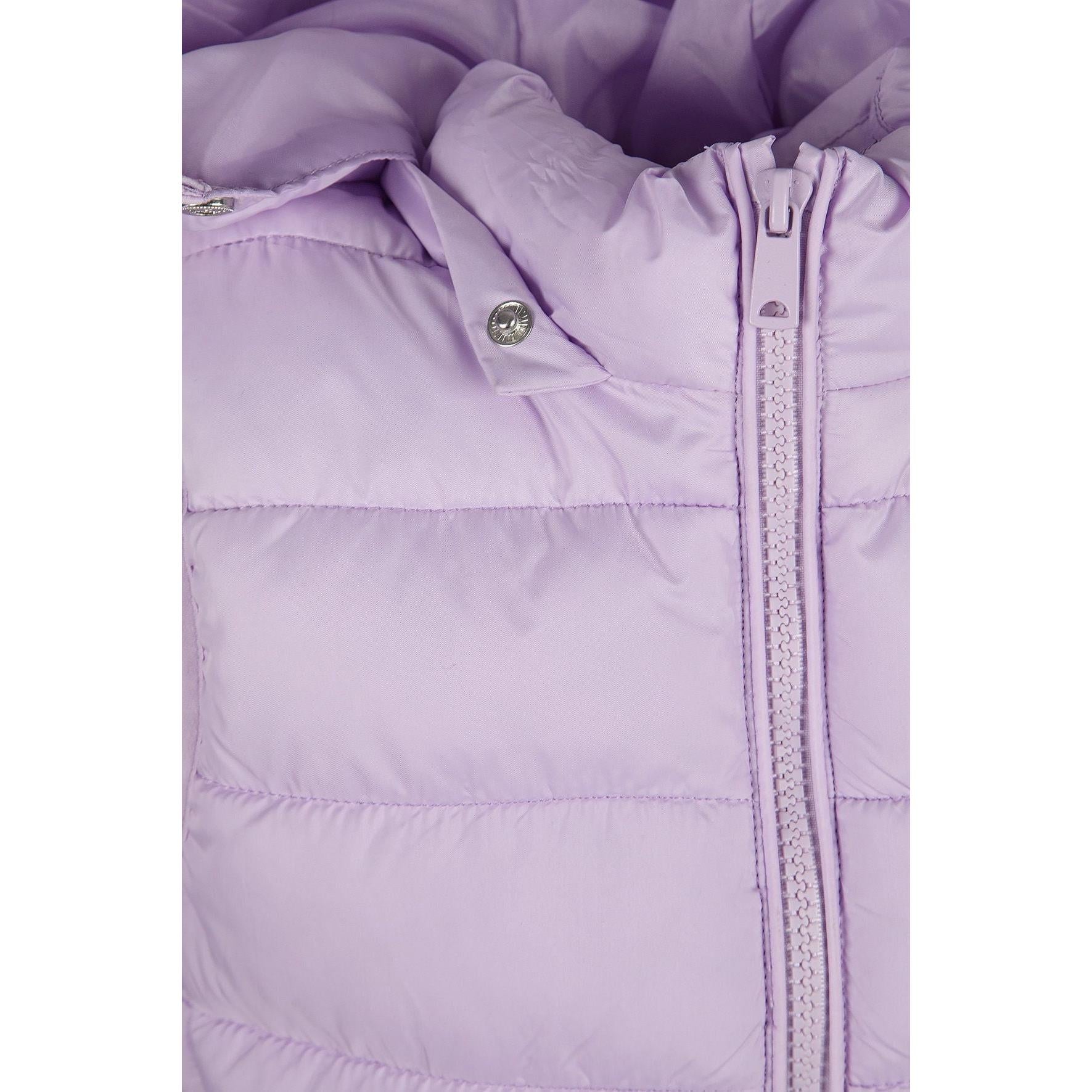 Close-up detail of lilac quilted fabric texture showing stitching pattern and Minoti brand label with glitter finish