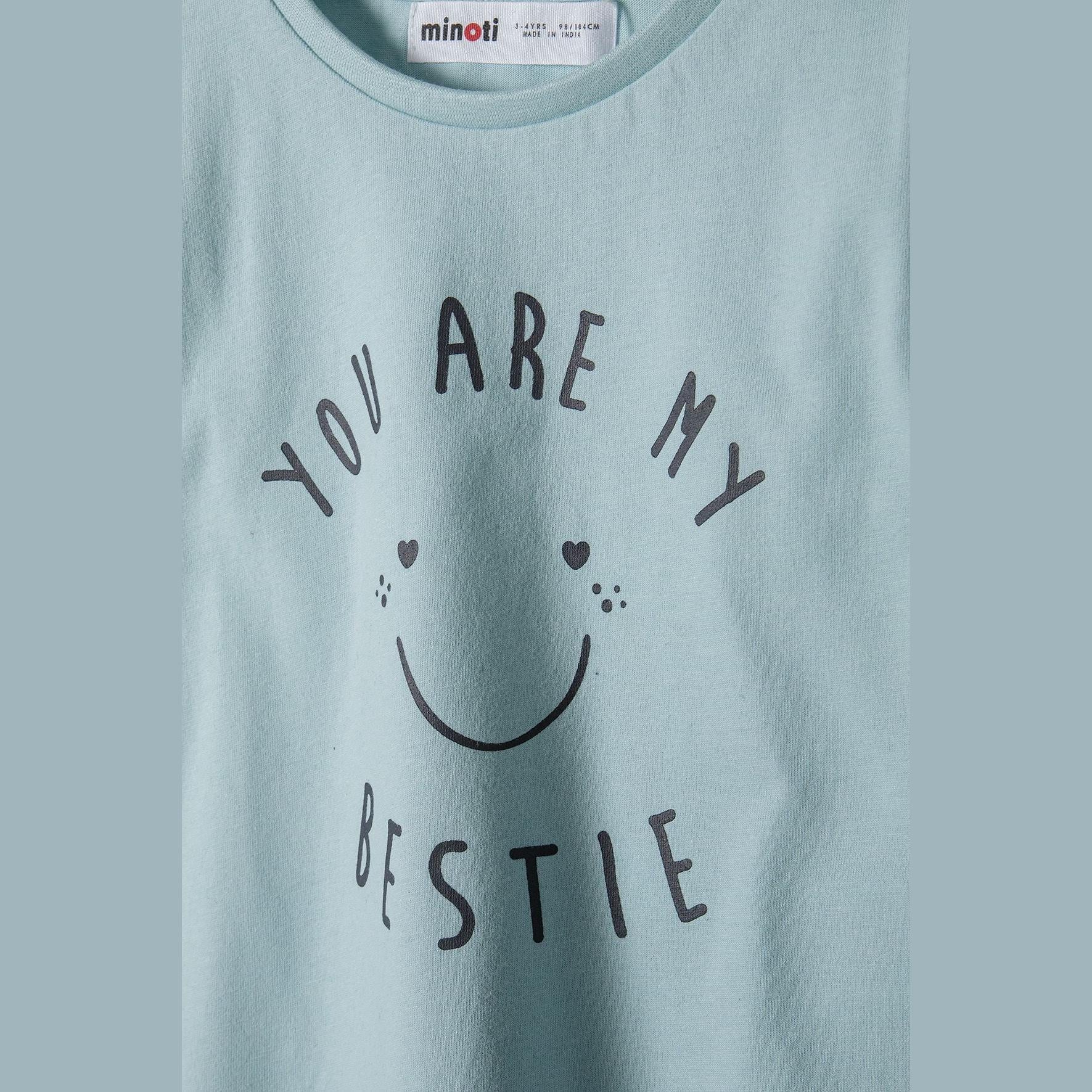Close-up detail of you are my bestie text with smiley face print on mint fabric with Minoti label visible