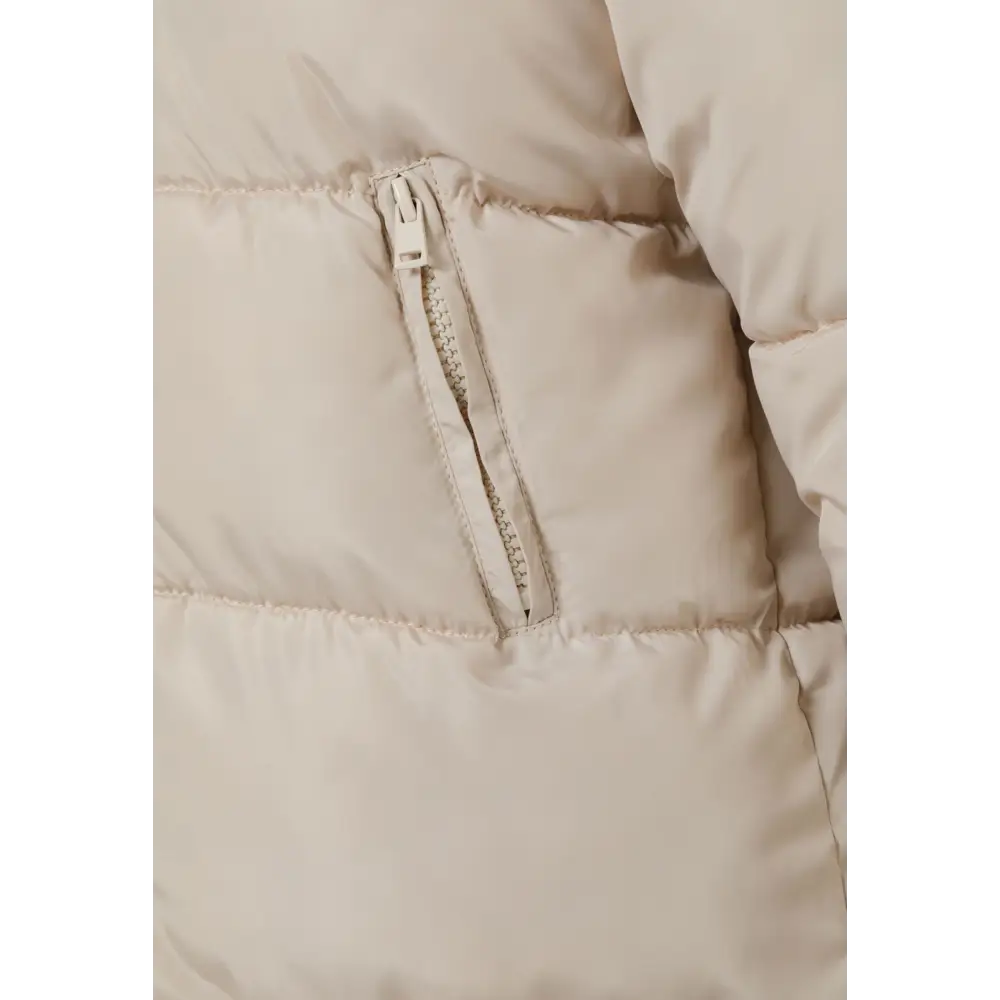 Close-up detail of beige parka jacket showing quilted texture, snap button closures and padded construction