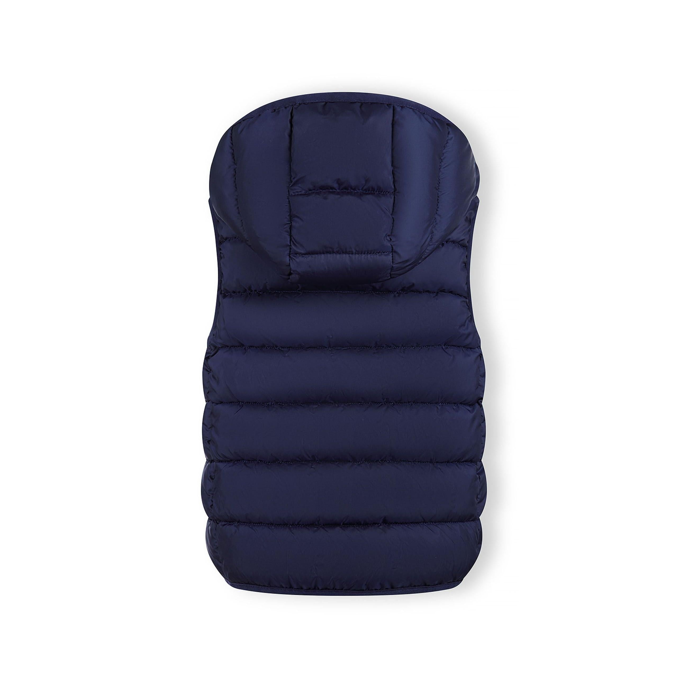 Close-up detail of navy quilted fabric texture showing stitched panels and holographic Minoti brand patch