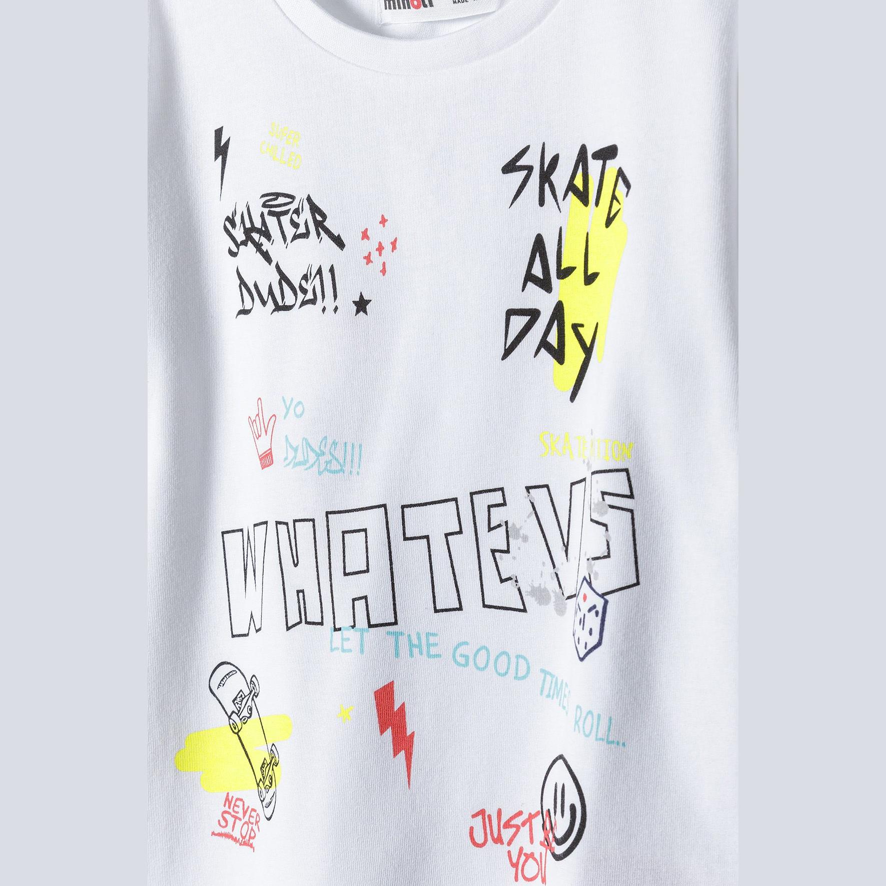 Close-up front view of white t-shirt showing detailed skateboard graphic with WHATEVS text and street art elements