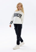 Girls cargo joggers with side combat pockets black 2-14y paired with a cozy Brooklyn hoodie for a stylish casual look.