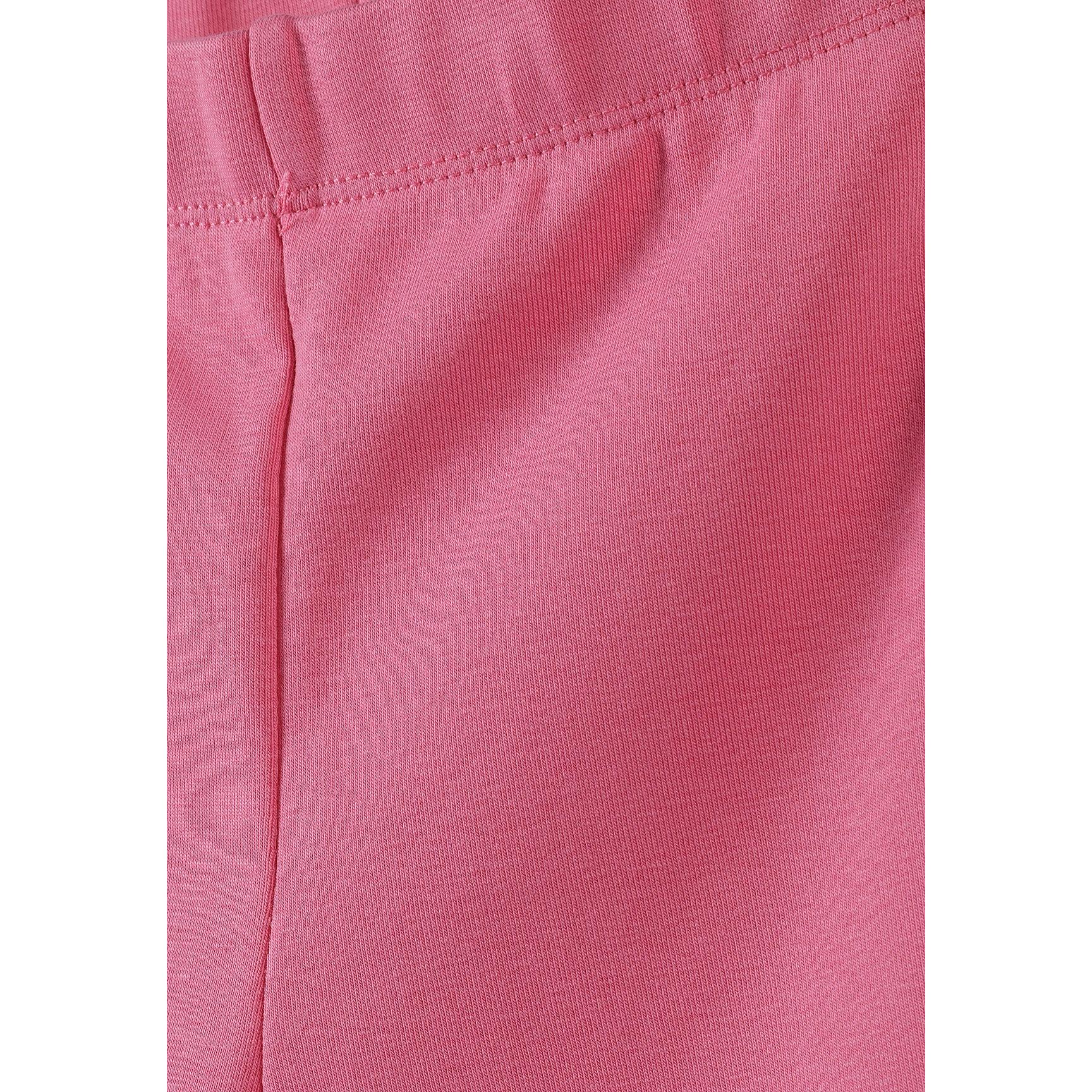 Close-up detail of pink jersey fabric showing ribbed texture and seam construction