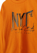 Bold orange long sleeve t-shirt featuring NYC graphic prints in black. Soft, breathable fabric for kids 2-14y. Perfect for casual wear.