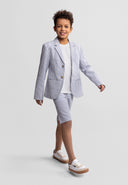 Boy wearing a stylish tailored striped cotton blazer and shorts set, walking confidently in casual white sneakers.