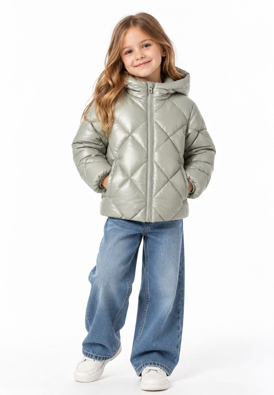 Girl wearing a shiny silver quilted hooded puffer jacket with a front zip and side pockets, paired with wide-leg blue jeans and white trainers.