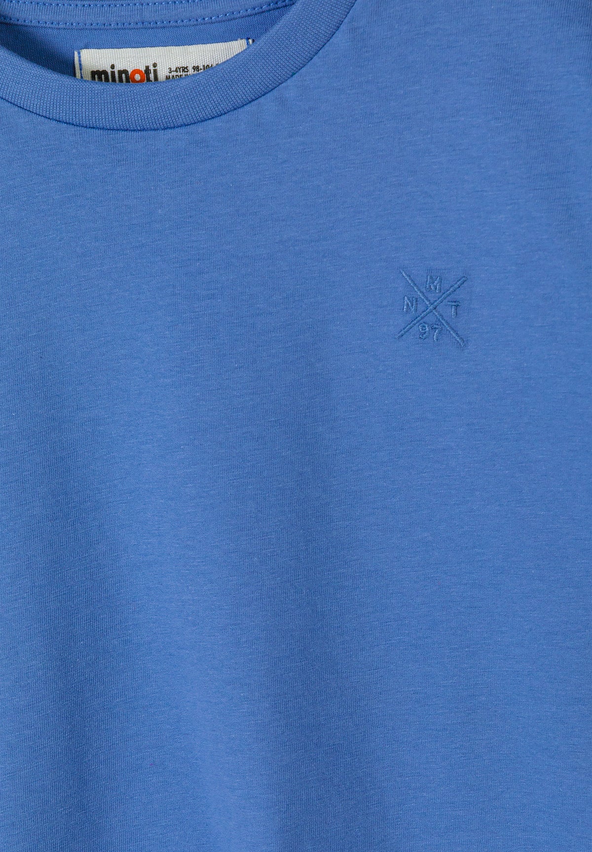 Close-up detail of blue cotton t-shirt showing fabric texture, crew neckline and small embroidered logo