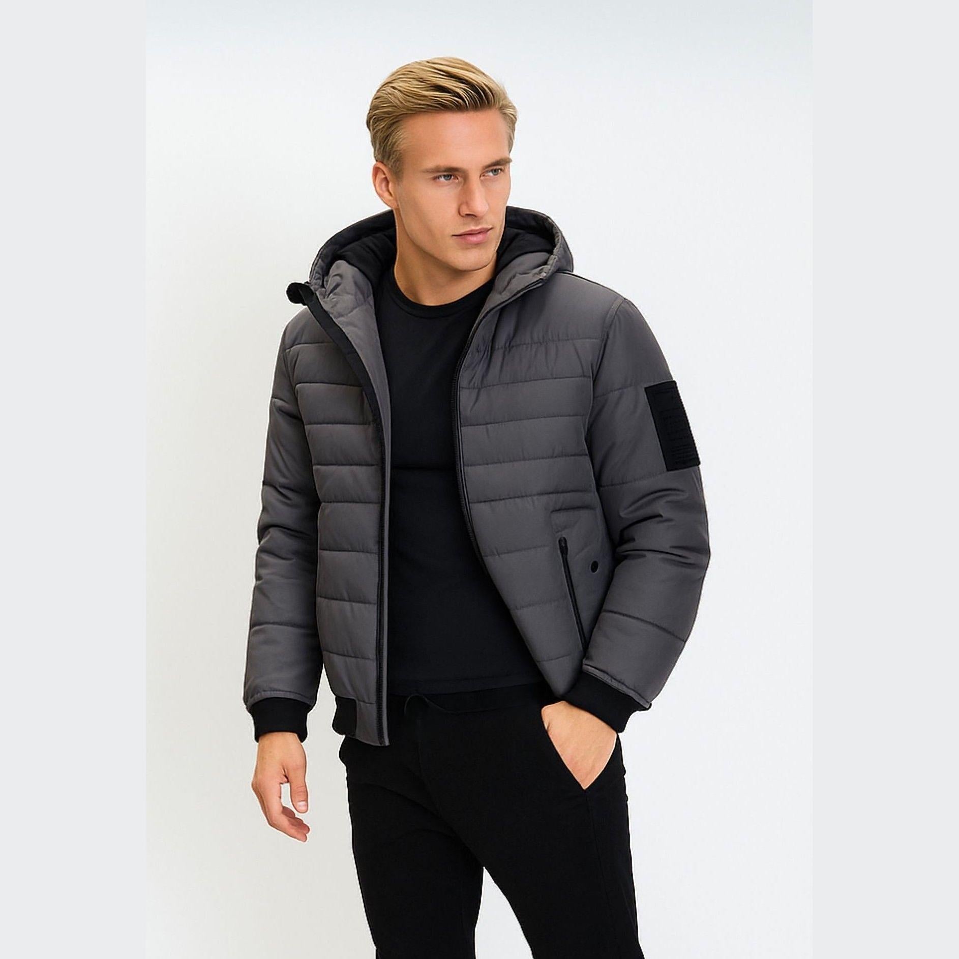 Men's grey padded jacket with hood, ribbed cuffs, zippered pockets, and sleeve badge.